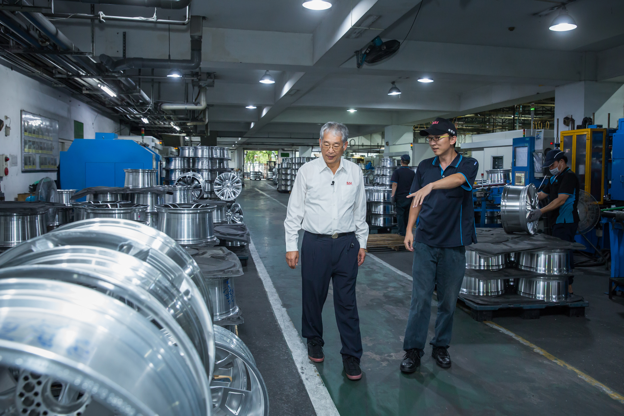 巧新科技董事長黃聰榮(左)出身雲林農家,半工半讀考上大學,一路打拚,從自行車廠小助理一路當到鍛造輪圈廠董座。