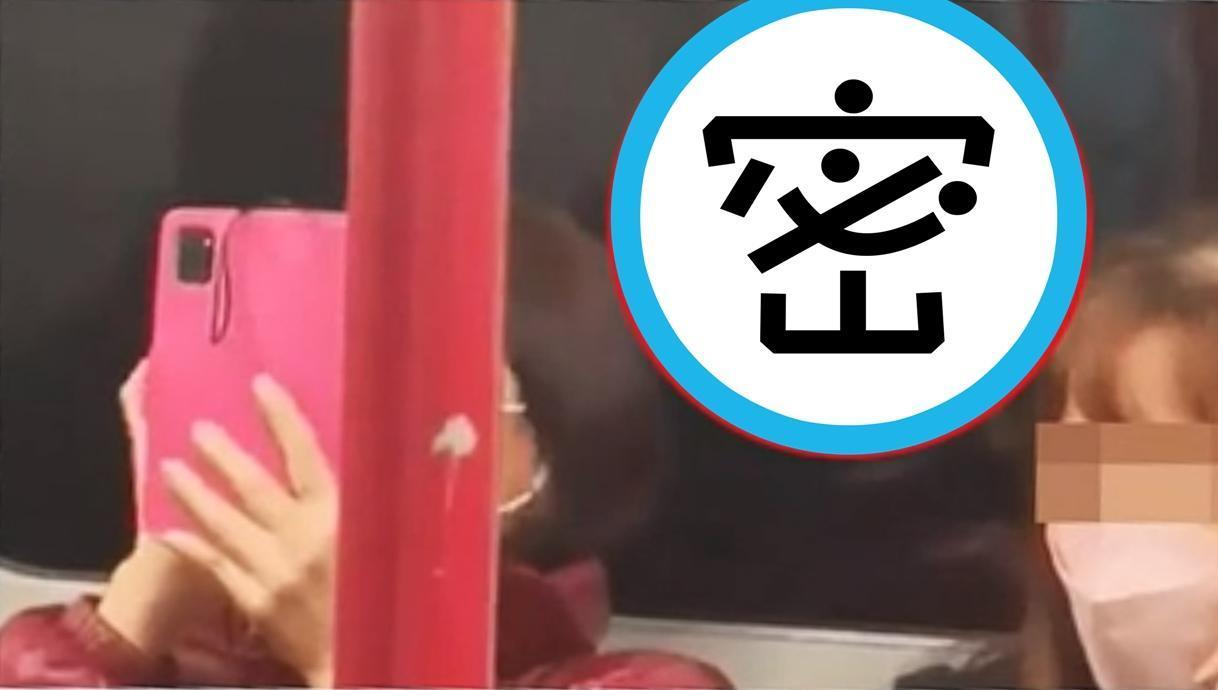 大媽一臉淡定看著手機,被其他乘客發現其實正在觀看謎片。(翻攝影片擷圖)