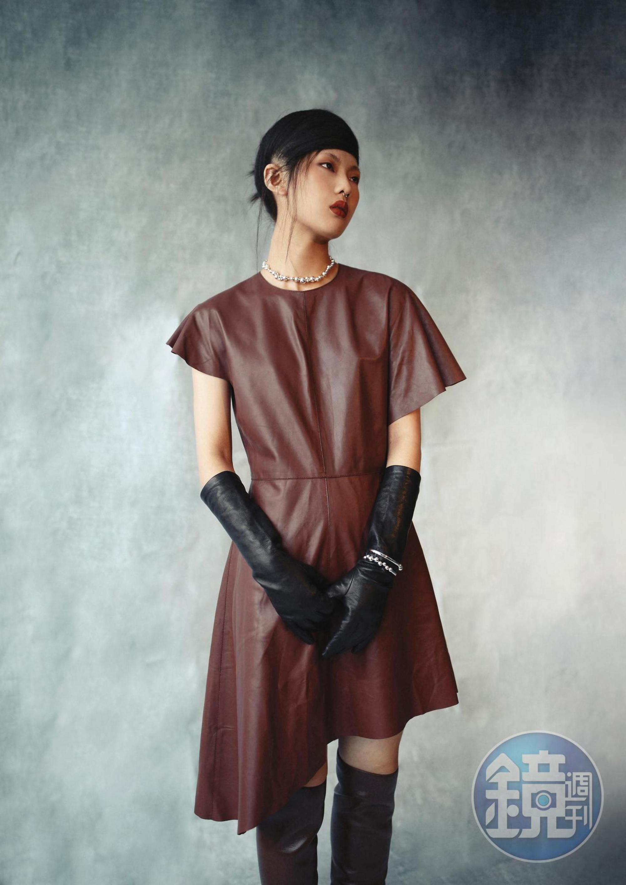不規則剪裁洋裝  價格店洽by LOEWE；MOSTRA深栗色高跟長靴 價格店洽by BOTTEGA VENETA；那帕羊皮手套  價格店洽 by BOTTEGA VENETA；MOONLIGHT GRAPES系列純銀葡萄鎖骨鍊 NT$32,500 by GEORG JENSEN；MOONLIGHT GRAPES系列純銀手鐲 NT$18,500 by GEORG JENSEN