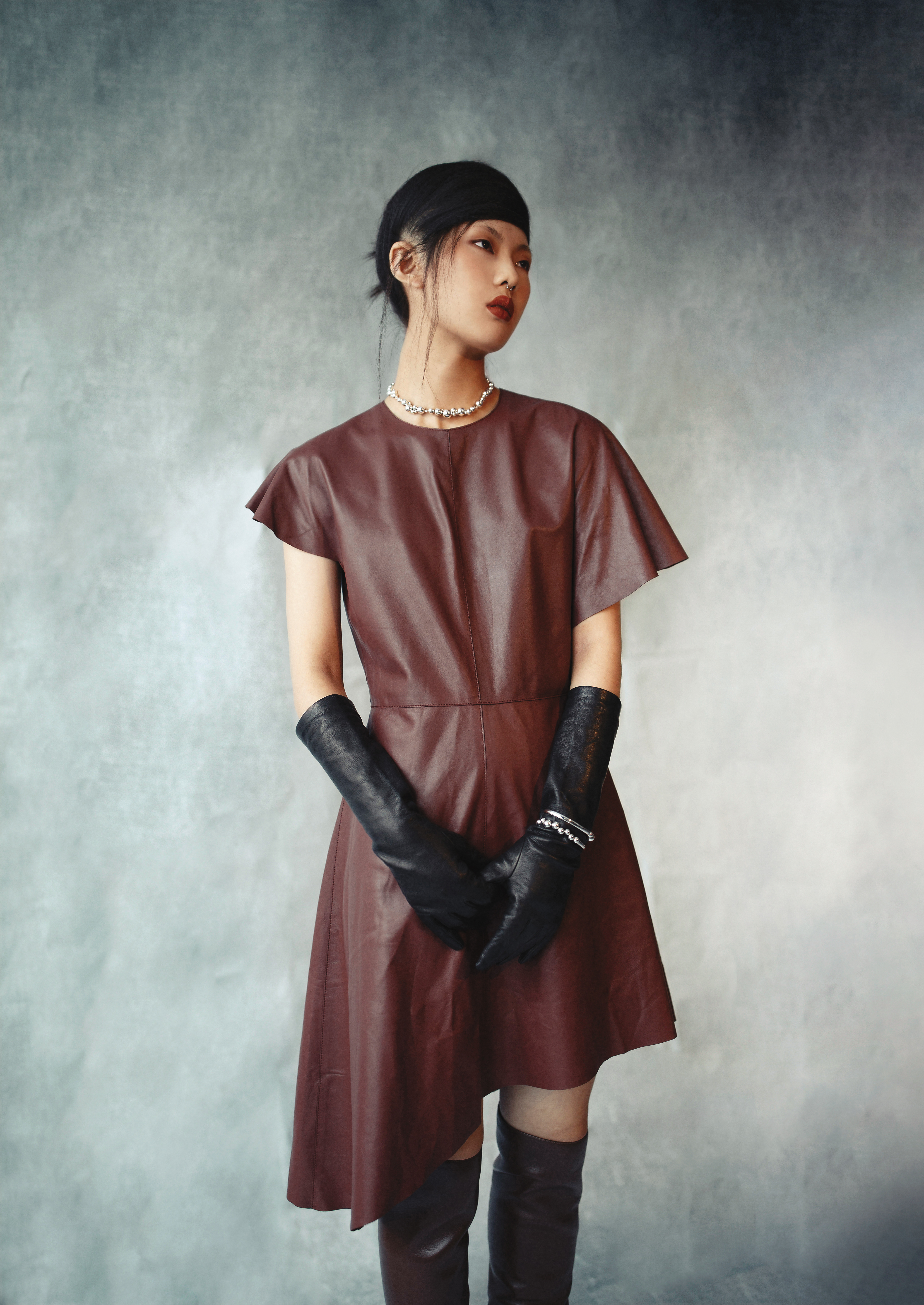不規則剪裁洋裝 價格店洽by LOEWE;MOSTRA深栗色高跟長靴 價格店洽by BOTTEGA VENETA;那帕羊皮手套 價格店洽 by BOTTEGA VENETA;MOONLIGHT GRAPES系列純銀葡萄鎖骨鍊 NT$32,500 by GEORG JENSEN;MOONLIGHT GRAPES系列純銀手鐲 NT$18,500 by GEORG JENSEN