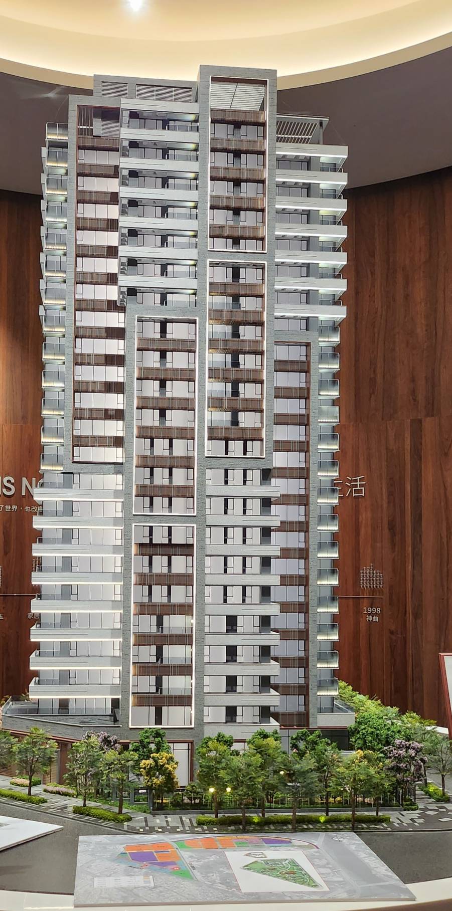 「家居璽玉」外觀是由建築師李文勝設計，以Nature、Tree、Wood、Green放鬆元素為靈感，自然有機語彙搭配溫潤木色跳色格柵，鑲嵌綠蒙卡石材肌理，創造包被感的陽台，與綠景融合無間。