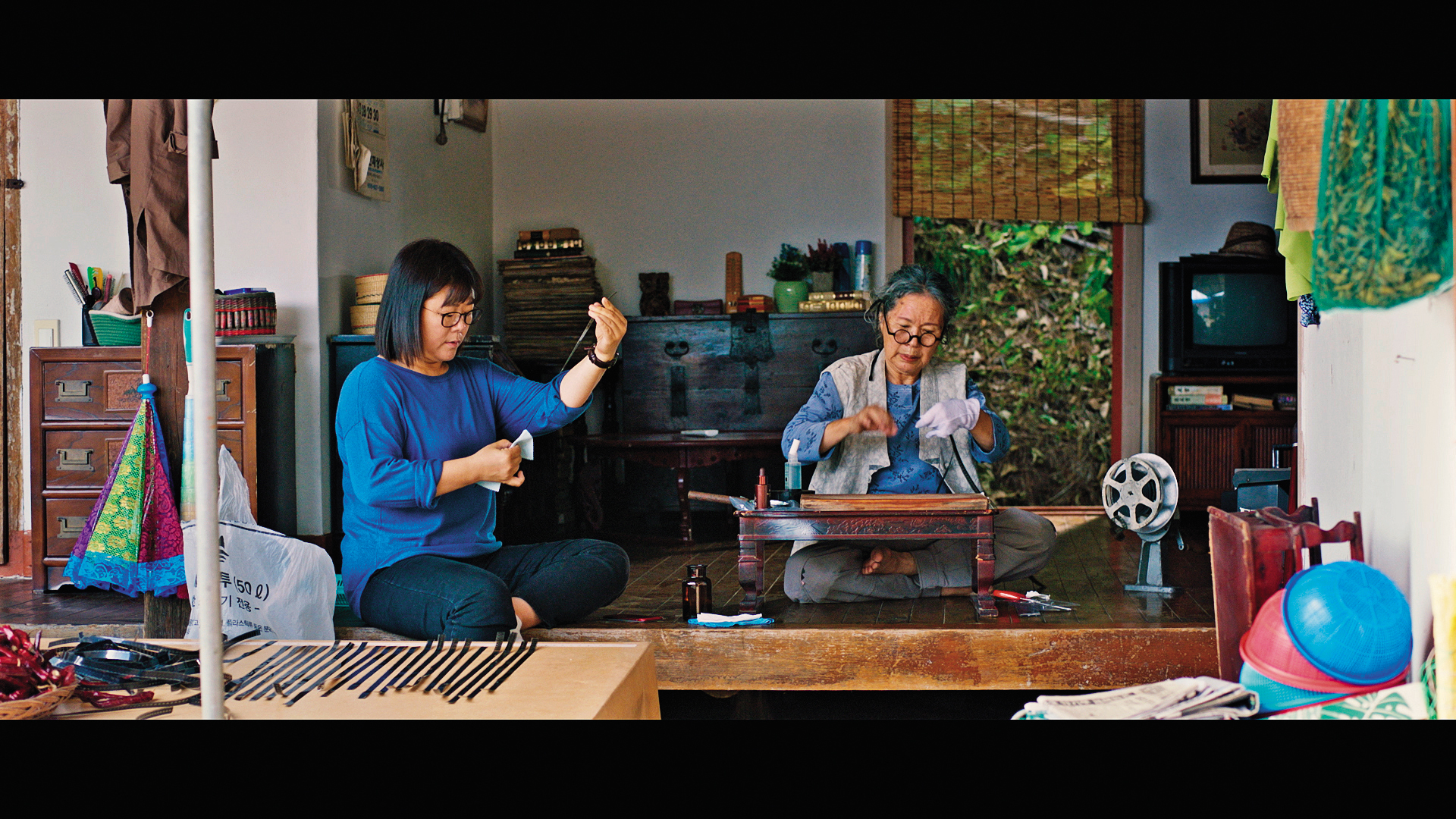 李姃垠（左）在《女影人生》飾演電影導演，與曾擔任剪輯師的李珠實（右）攜手修復經典電影《女法官》的膠捲。（可樂電影提供）