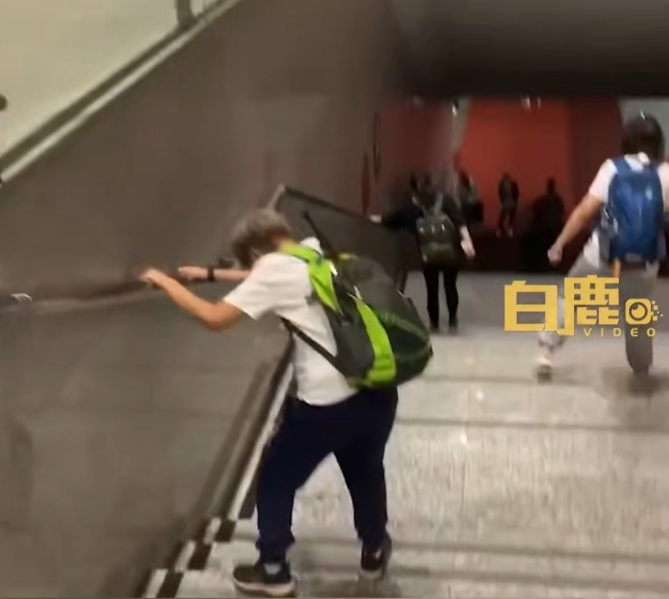 網友因鐵腿，只能雙手扶著側邊欄杆，一步一步邁下階梯。（翻攝微博）