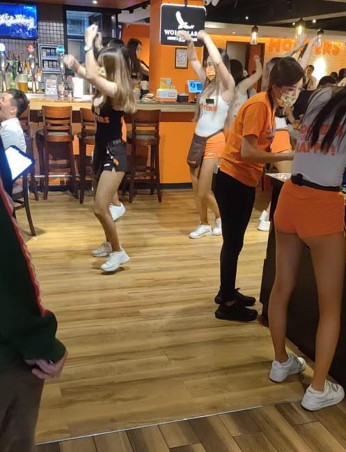 知名美式餐廳女服務生穿著招牌短褲,大跳熱舞炒熱氣氛。(翻攝臉書社團「外送員的奇聞怪事」)