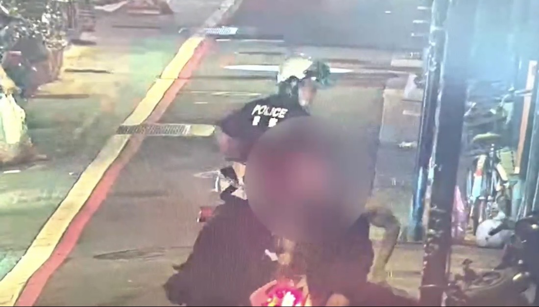 移工將騎在機車上的警察推倒後逃走。（翻攝畫面）