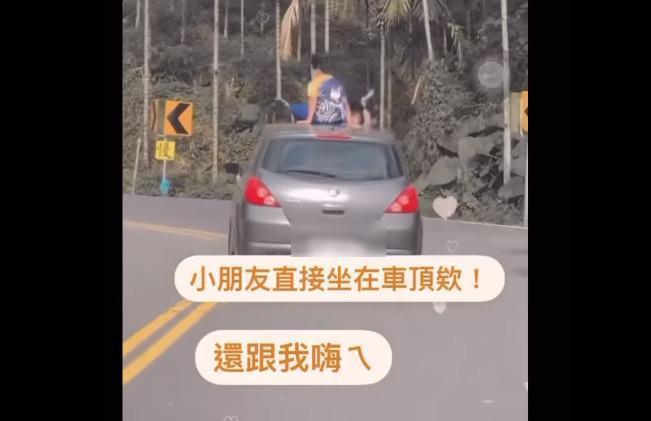 民眾開車行經嘉義梅山山區,目擊前車有2名小孩居然坐在車頂,且小孩竟還向後車揮手。(翻攝《爆廢公社公開版》)