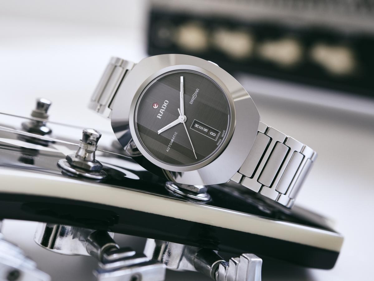 RADO DiaStar Original 60th Anniversary Edition 工業設計大師Alfredo Häberli以簡約的銀色面盤、六角切割藍寶石水晶鏡面與Ceramos™碳化鈦金屬陶瓷製的拉絲紋錶圈，重新改造DiaStar的面貌。光影迷離的視覺效果與復古錶圈對比強烈。6點鐘位置的星期顯示改成伸縮棒狀，由觀者自行判斷。搭載R764自動上鏈機芯，擁有80小時動力儲存；附有米蘭帶與紡織帶二條錶帶。 功能：時、分、秒指示；日期顯示；星期週期顯示 機芯：自動上鏈機芯 定價：約NT$57,200