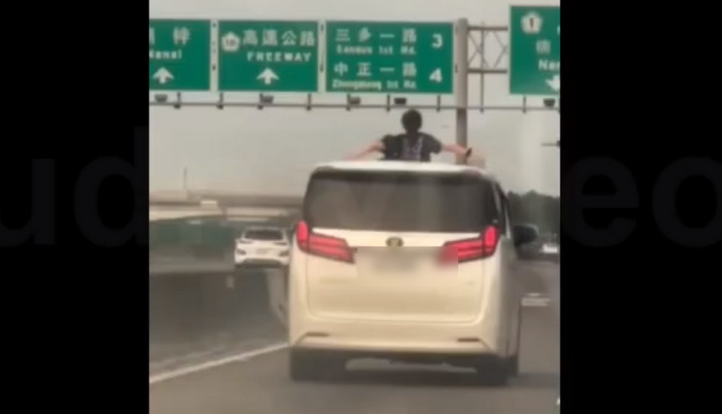 國道上有2名女童上半身探出車頂天窗，大舉雙臂兜風。（翻攝臉書社團《爆料公社公開版》）