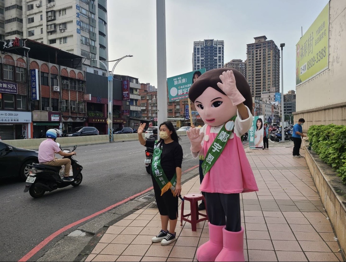 新北市議員鄭宇恩帶著分身大頭娃娃路口拜票（鄭宇恩提供）