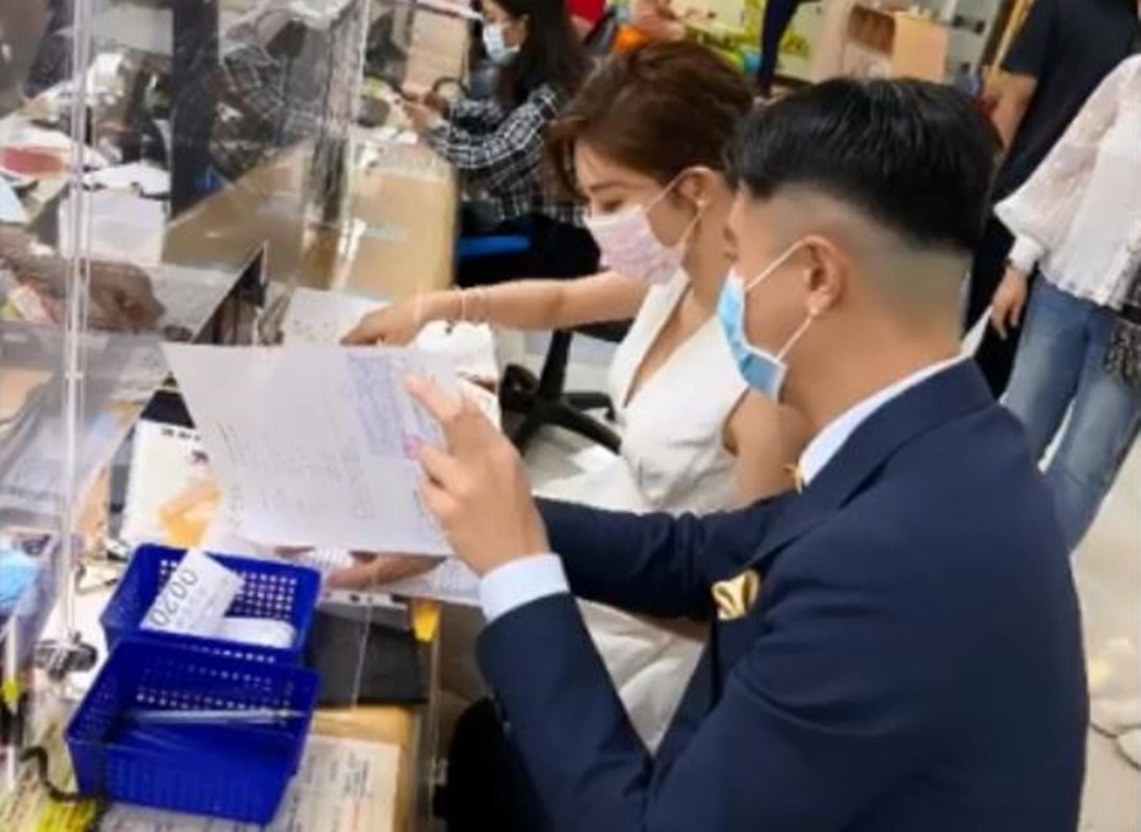 吳亞馨今天身穿白色低胸小洋裝，男方一身藍色西裝，兩人在內湖戶政事務所櫃檯的文件上簽字。（翻攝自網路）