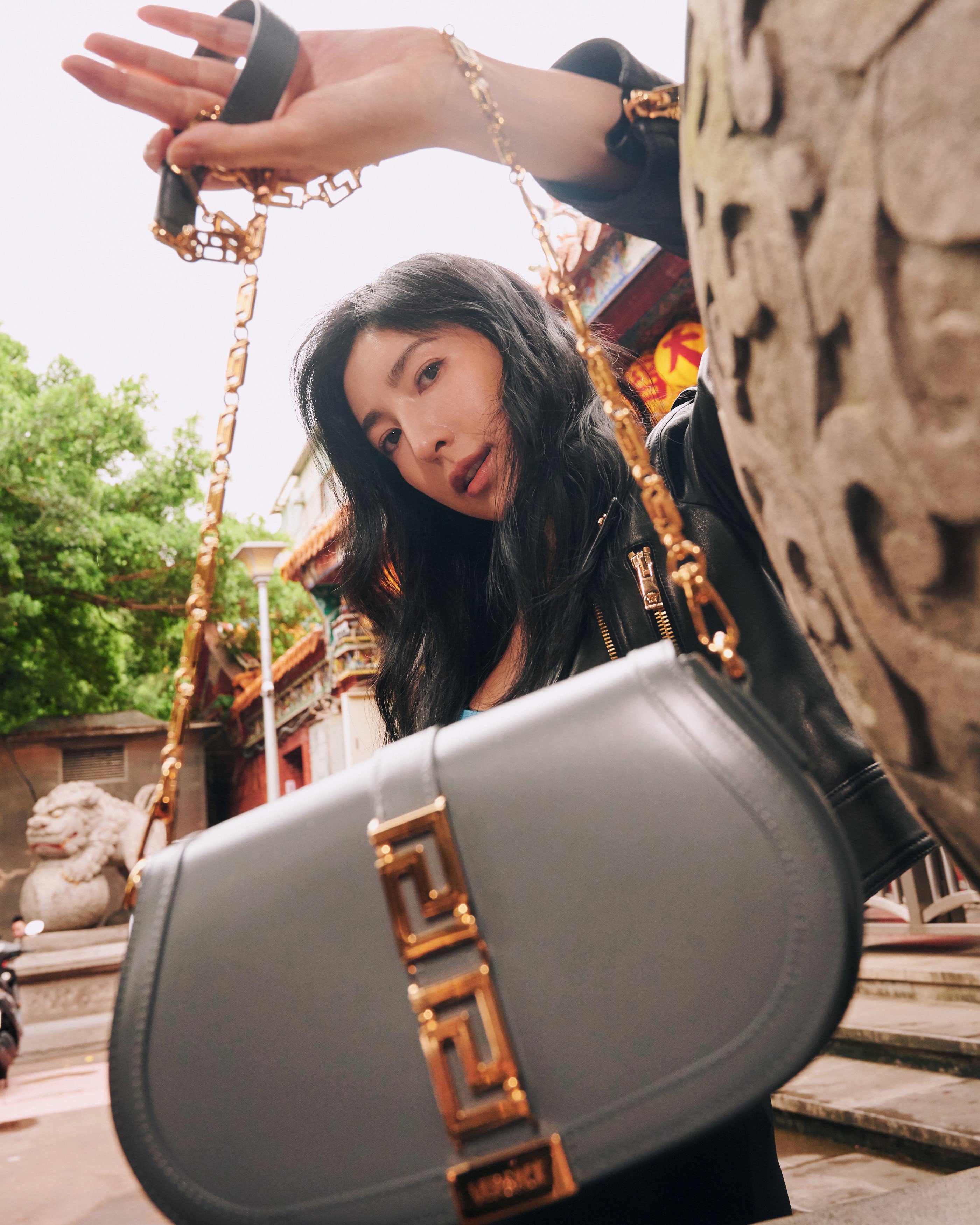 楊謹華穿著黑色騎士皮外套,以帥氣詮釋全新Greca Goddess迷宮女神包。(VERSACE提供)