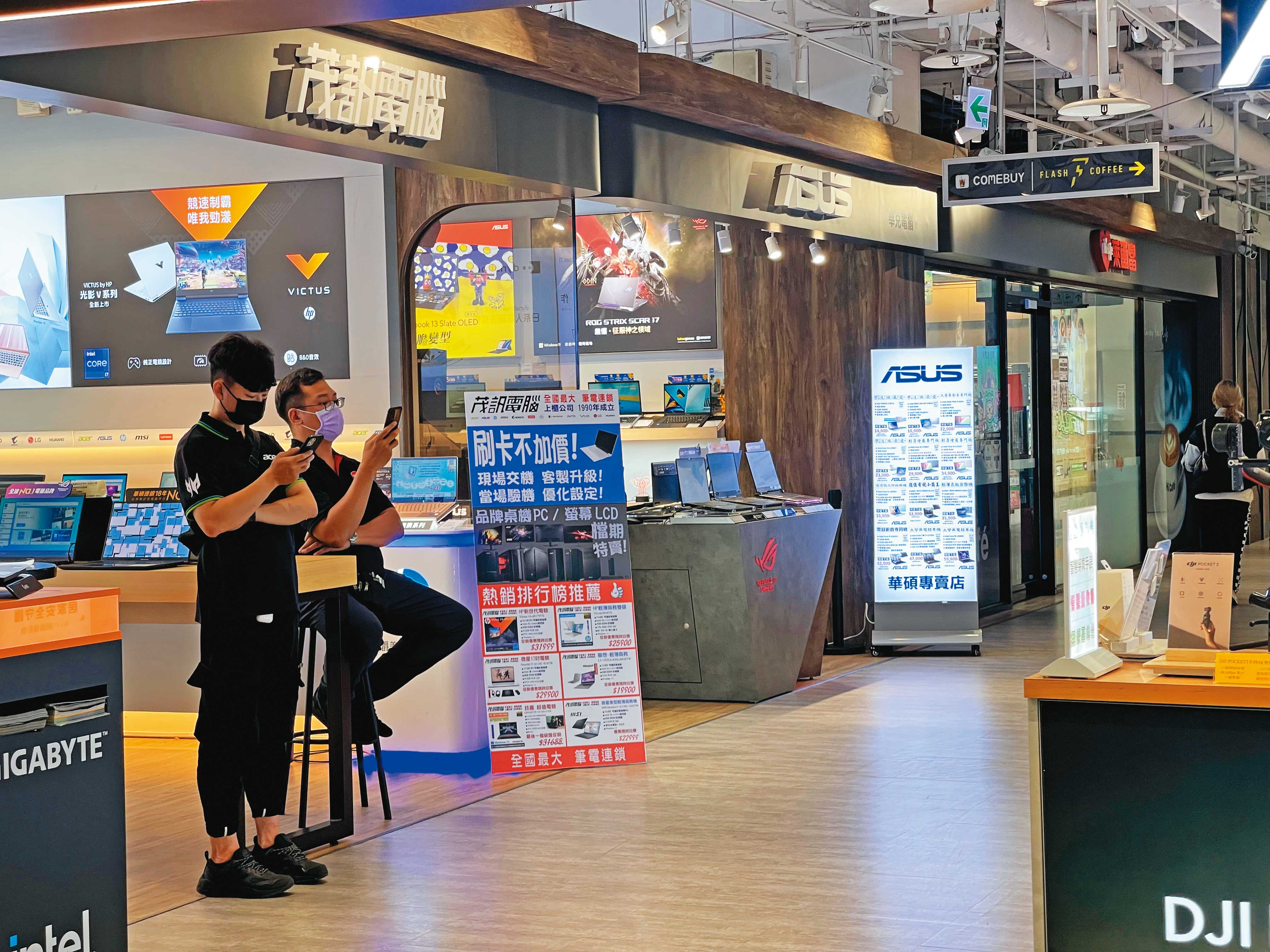 3C聖地光華商場受景氣影響，近期買氣清淡，店員只好滑手機打發無聊時間。