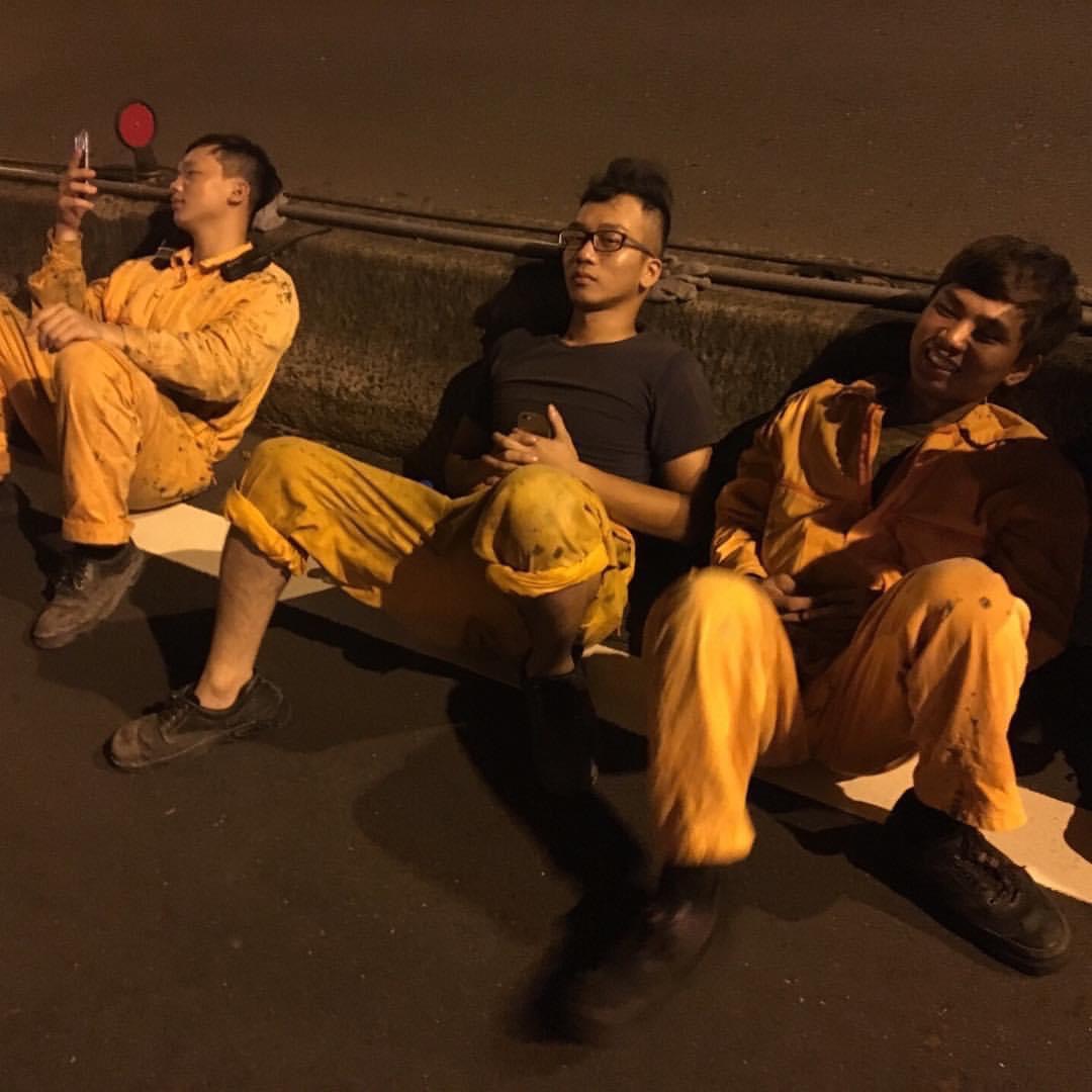 20多歲時的小姜(中)曾是塔吊工人,午夜到工地拆完塔吊台,與同事累坐路邊。(小姜提供)