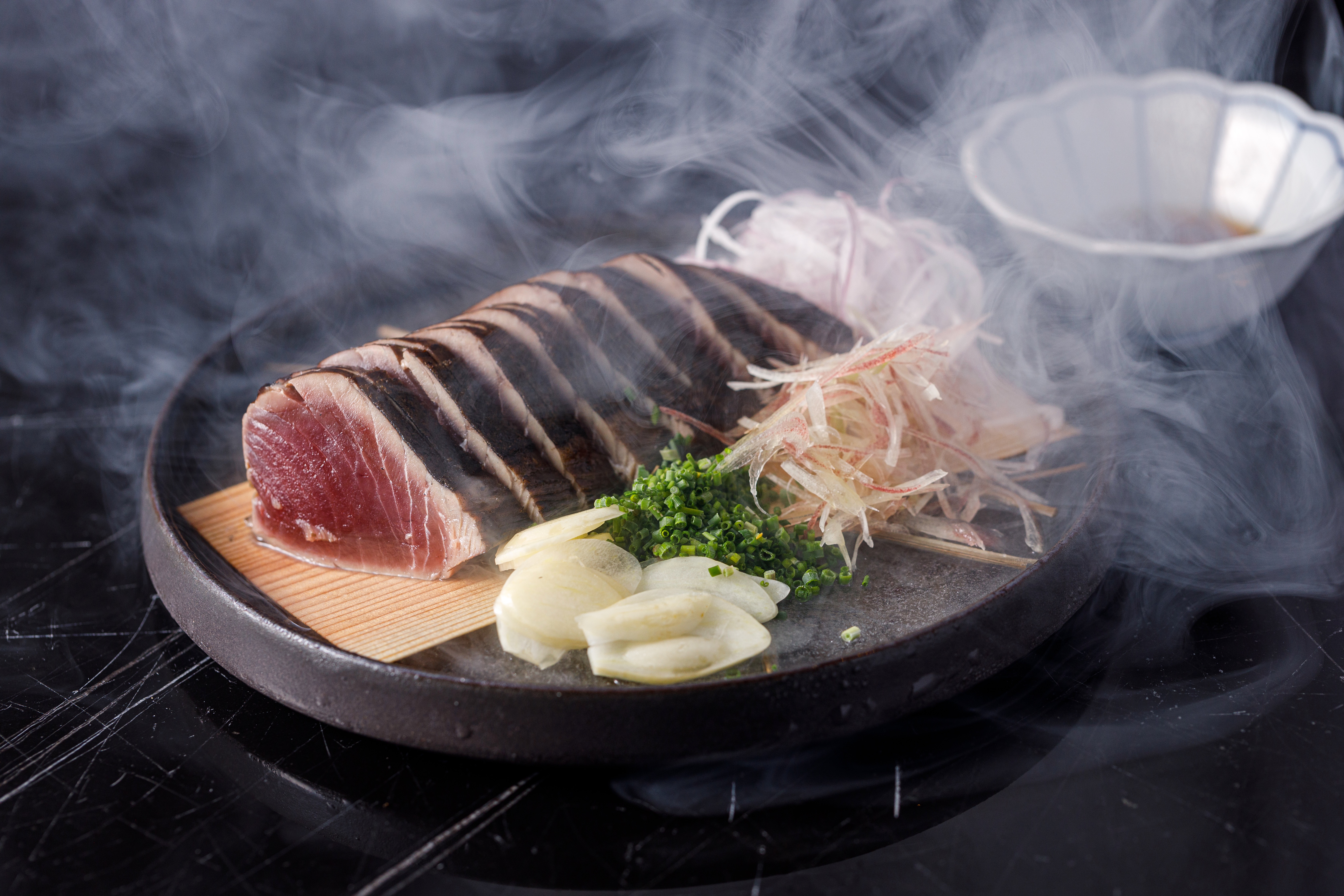 稻草燒經典料理「藁燒鰹魚半敲燒」，半生熟的肉質充滿煙燻味，格外下酒。（380元／份）