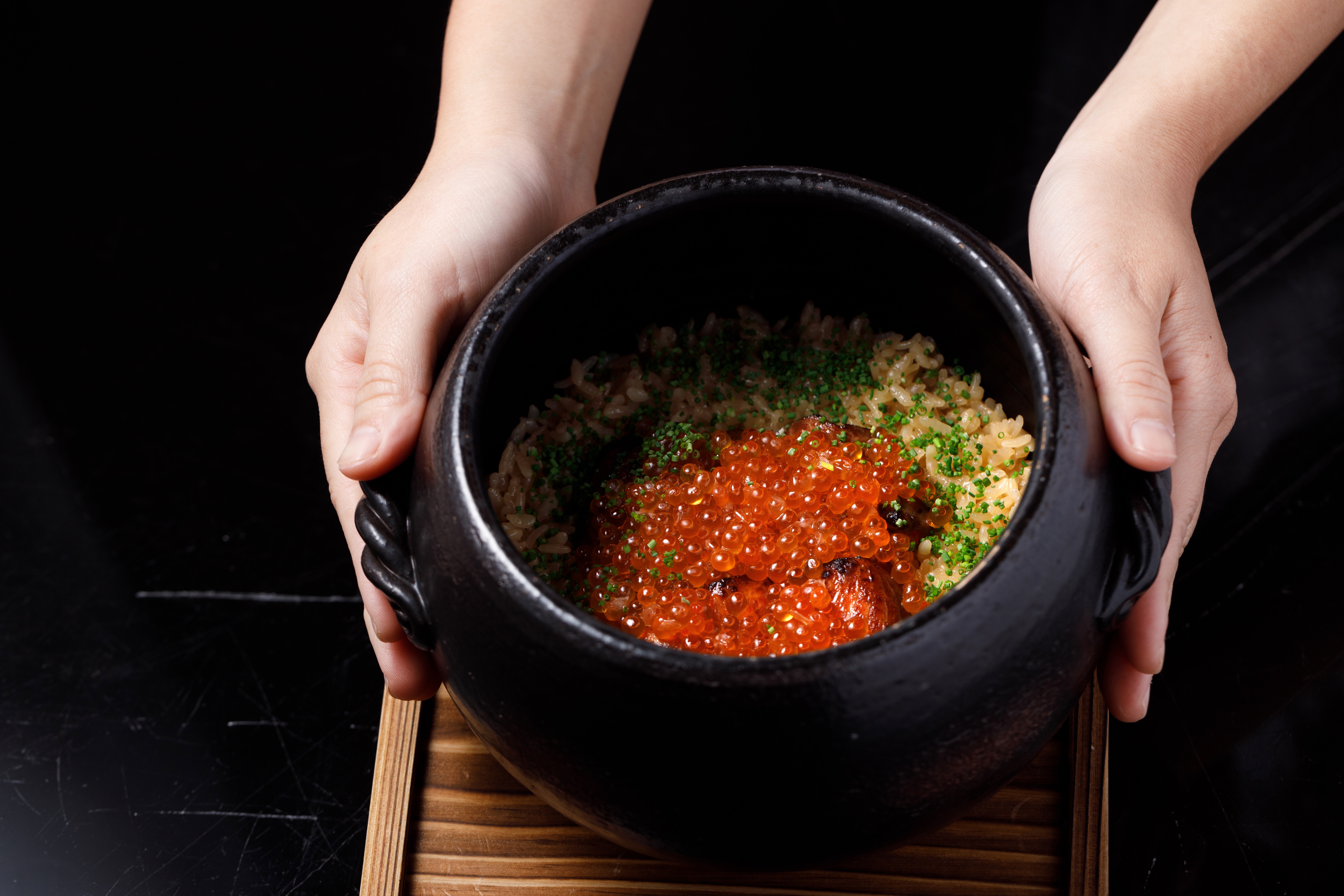 「藳燒鮭魚親子飯」的挪威鮭魚用稻草稍微炙燒，鋪上北海道鮭魚卵，用土鍋炊蒸半小時的米粒，吸滿高湯精華。（760元／份）