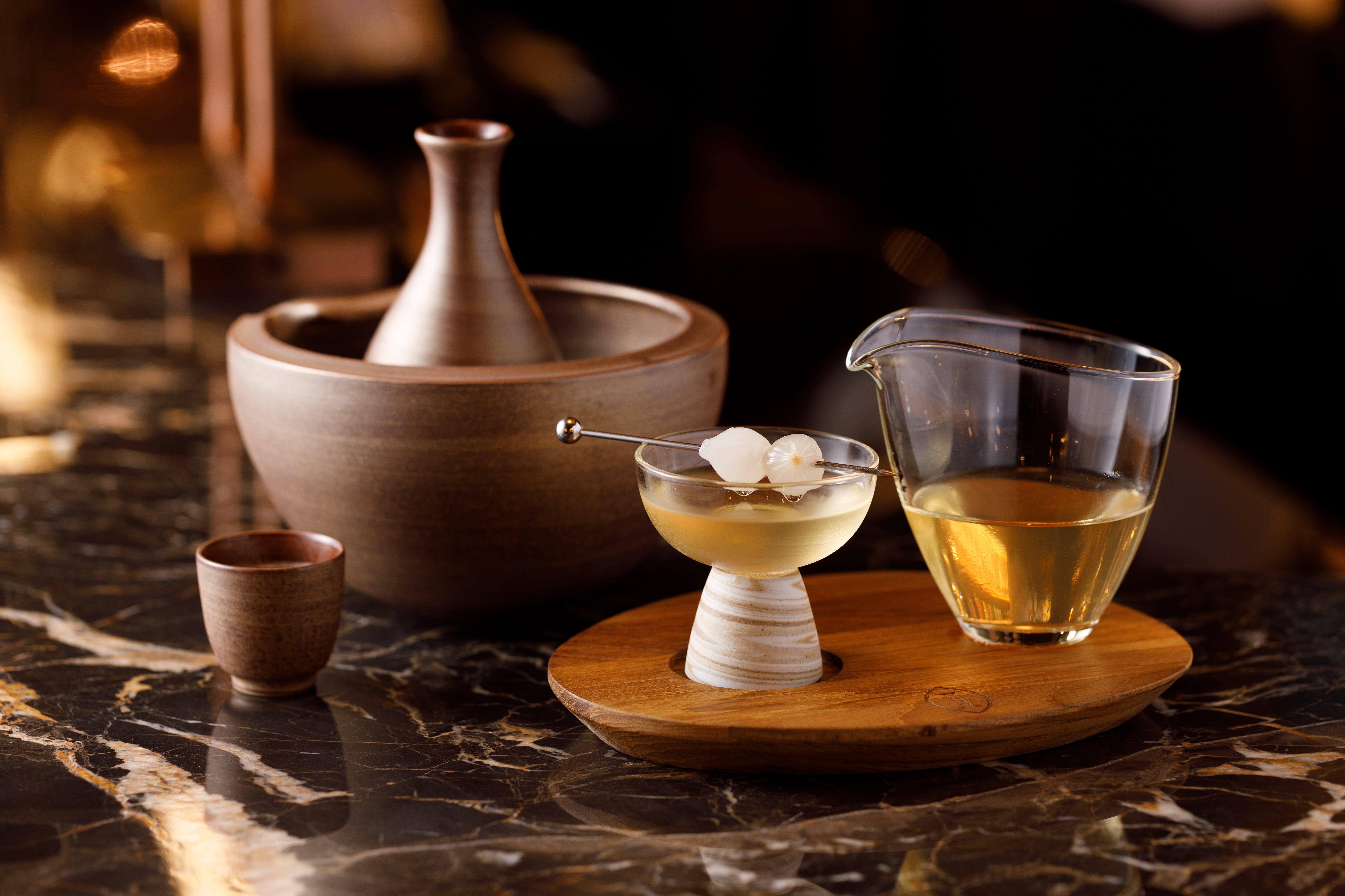 「調酒-WARA Tiniz（右）」以純米吟釀為基底，搭配自製香草葡萄汁，帶有紫蘇清香。「壽司手」用自製雪菊四季春琴酒，搭配柚子酒、奶香酒，酸甜帶奶香，竟有品嘗壽司米飯的感覺。（皆400元／杯）