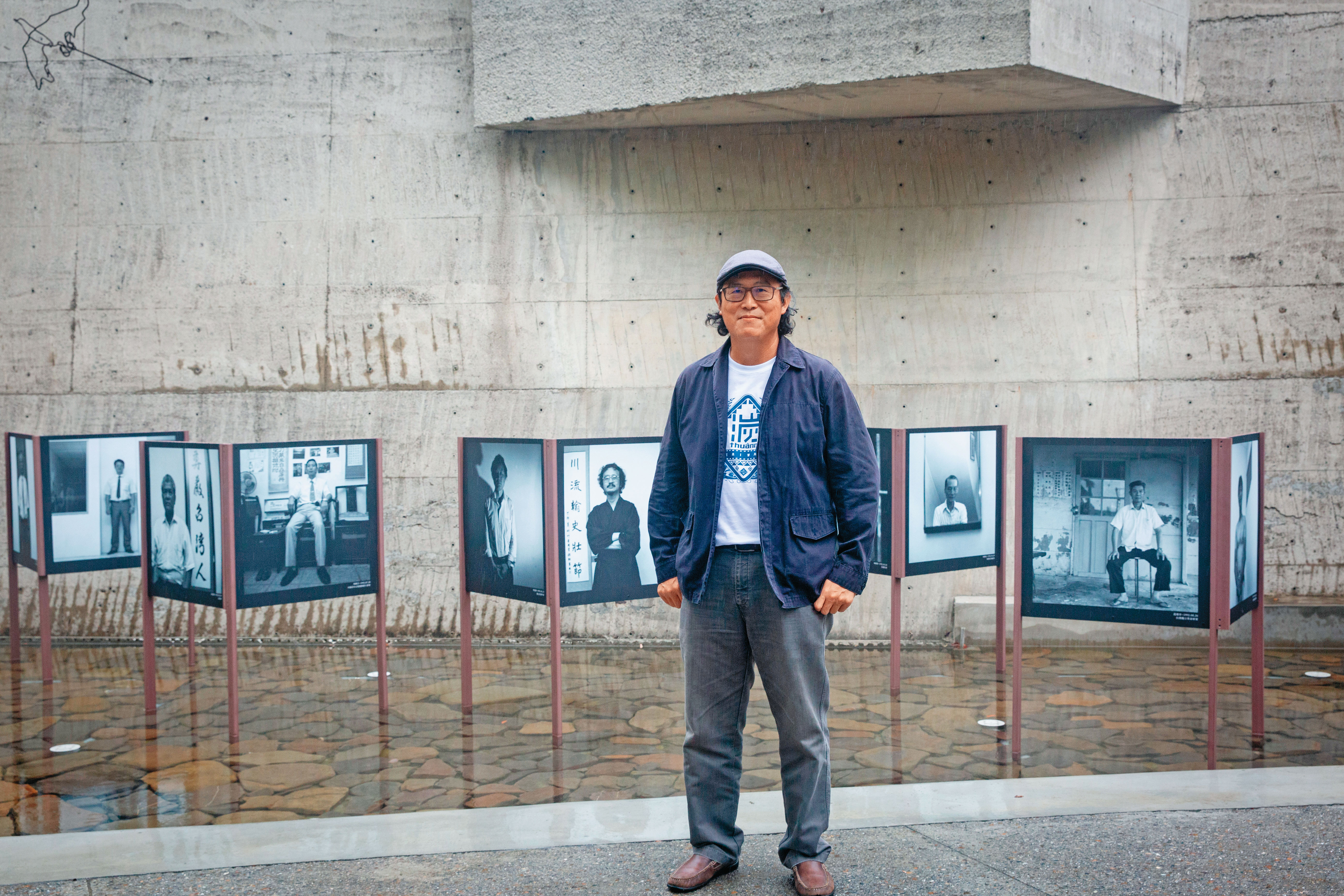 姚文智在景美人權園區，與白色恐怖受難者的肖像合影。