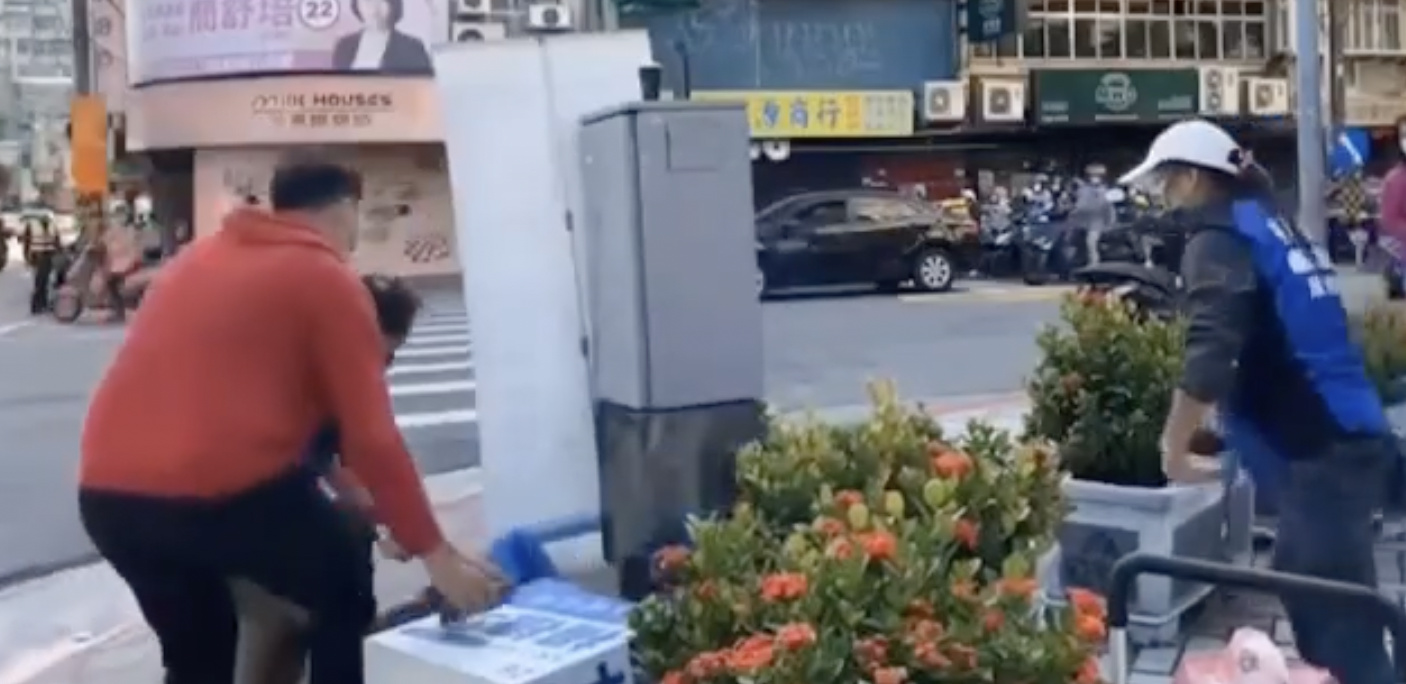 楊植斗從演講台上摔落，一旁工作人員緊急上前查看。（截圖自羅智強臉書）