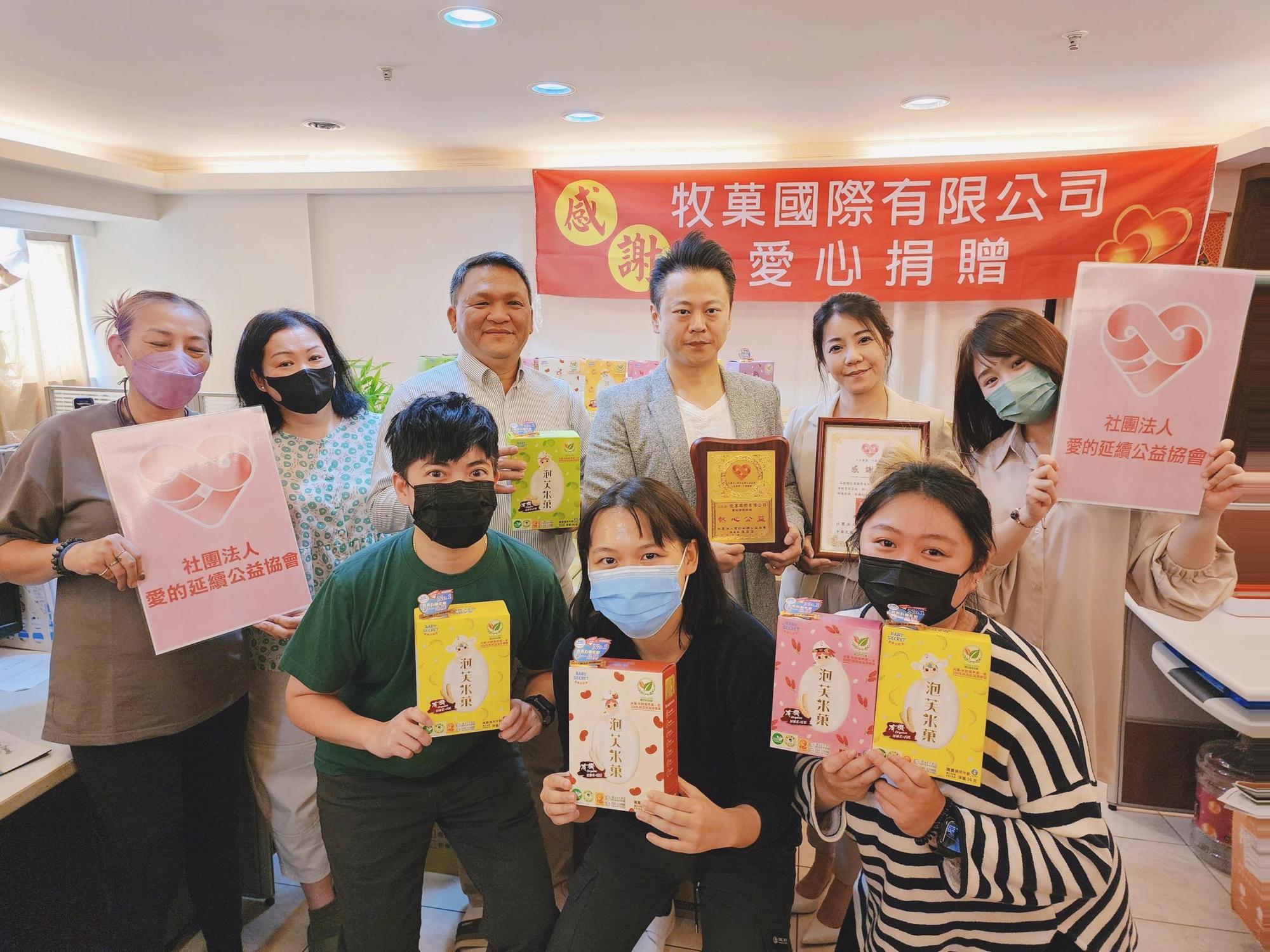 牧菓國際創辦人黃士旗(後排右三)及太太李星嬡(後排右二)捐助現金及有機泡芙米菓25箱給「社團法人愛的延續公益協會」。(牧菓國際提供)