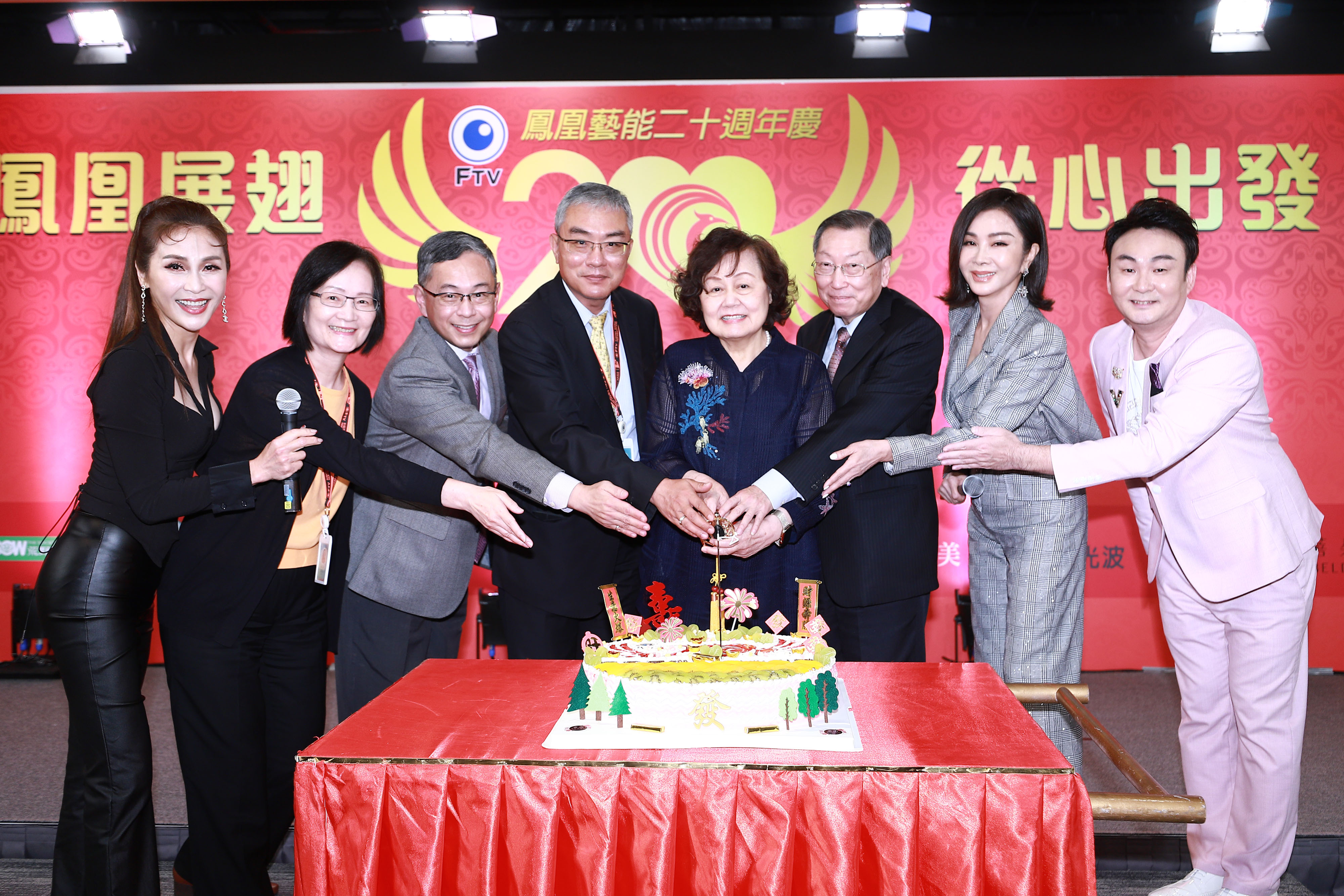 左起梁佑南、楊淑津副總、鳳凰總經理趙善意、許念台副總、王明玉董事長、廖季方總經理、陳美鳳、洪毛一起切蛋糕慶祝20週年生日快樂。（民視提供）