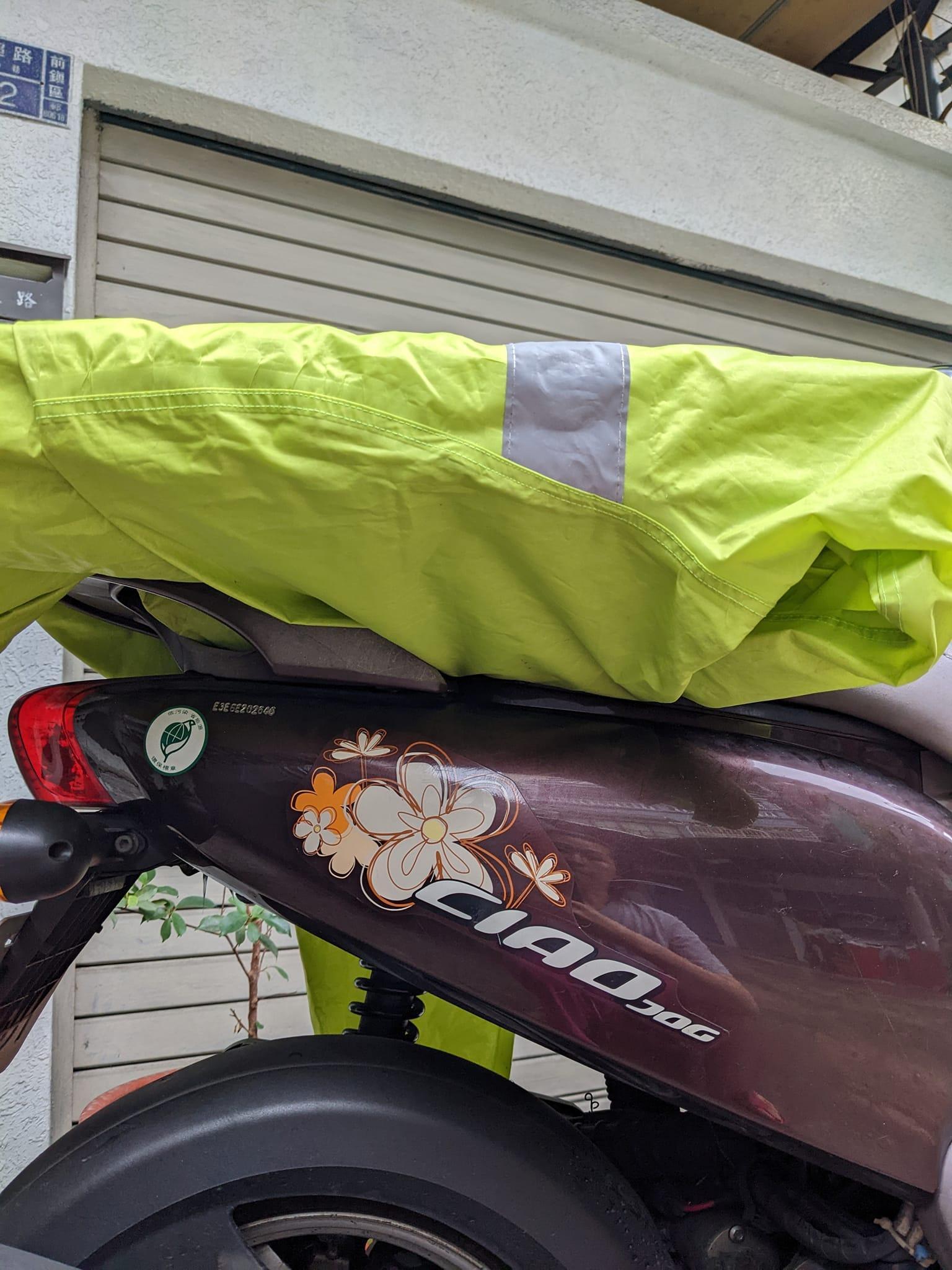 有網友分享如何用一件雨衣將整盒大披薩綁在機車後座。(翻攝自Costco好市多 商品經驗老實說)