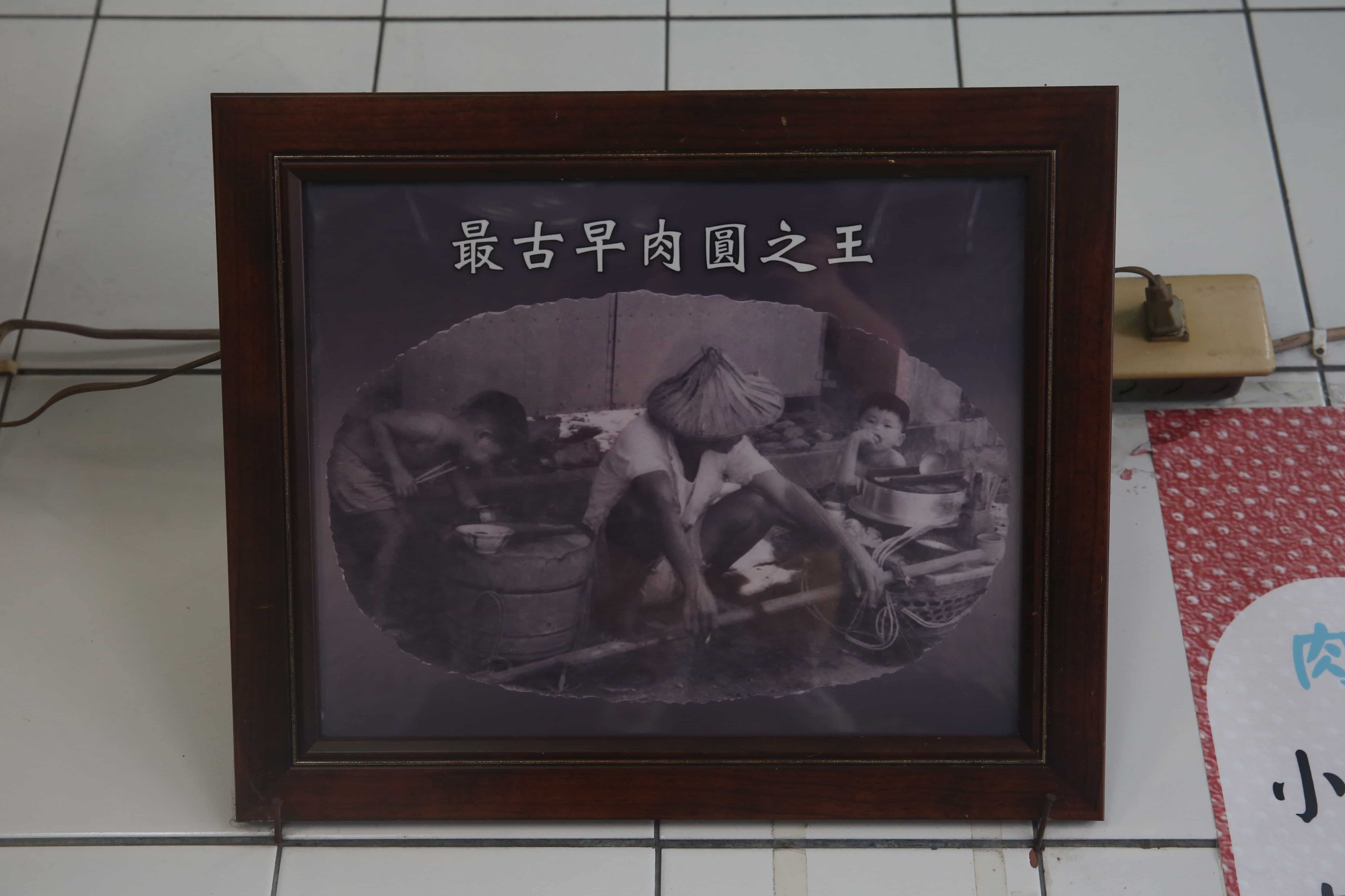 牆上珍貴的黑白照，記錄著「黃家肉圓」初代早期挑著扁擔叫賣的畫面。