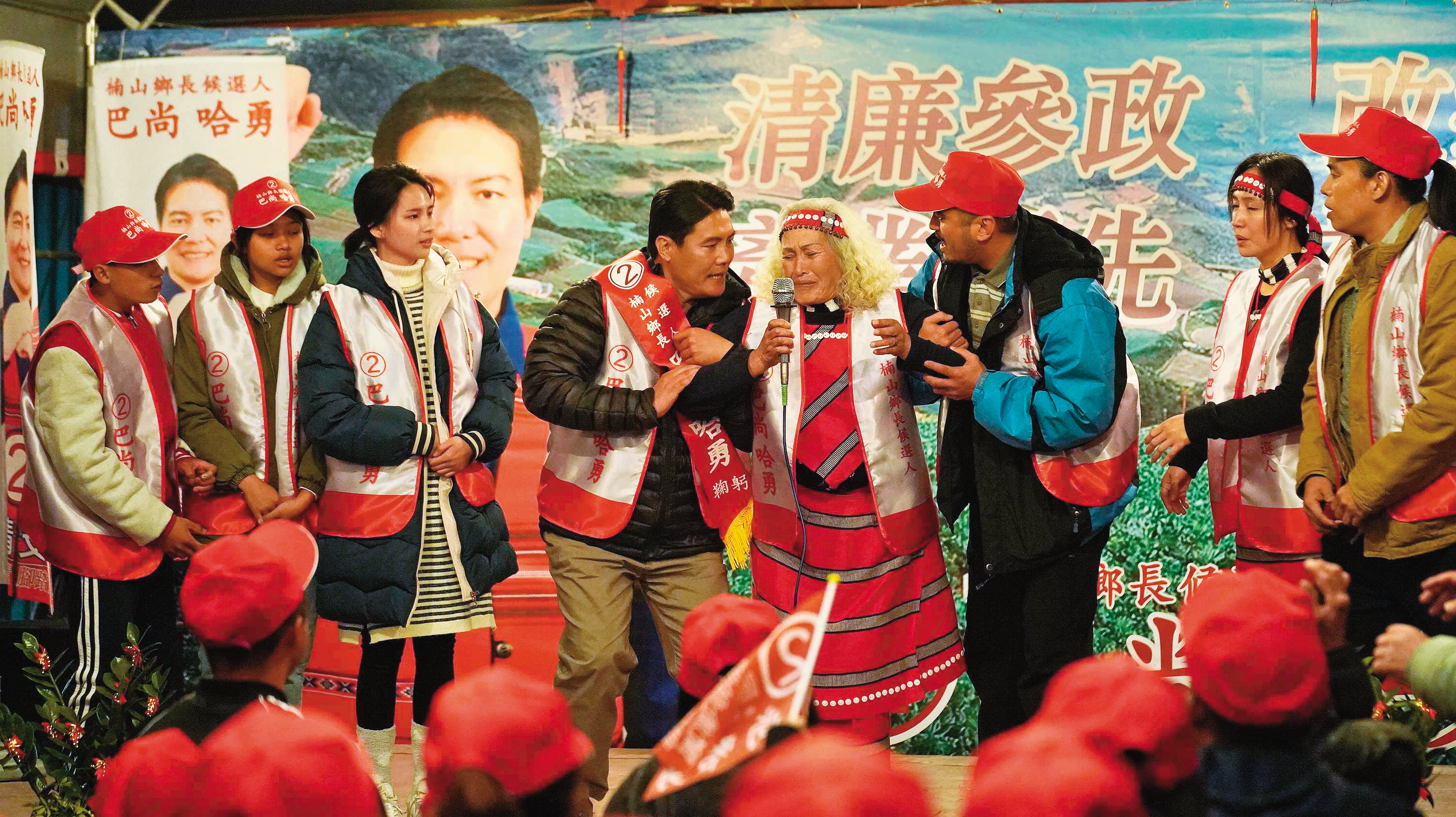 故事以選舉為背景,飾演鄉長候選人的洪金輝(左四)與戲中母親林詹珍妹(右四)上台向鄉親拉票。(華映提供)