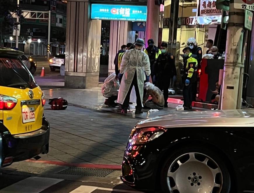 潘男持酒瓶自砸頭部，坐在騎樓等待救護車。（翻攝畫面）