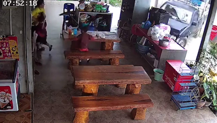 泰國一名母親和一對兒女帶在自家店外騎樓，未料一輛皮卡車暴衝進來。（翻攝自推特）