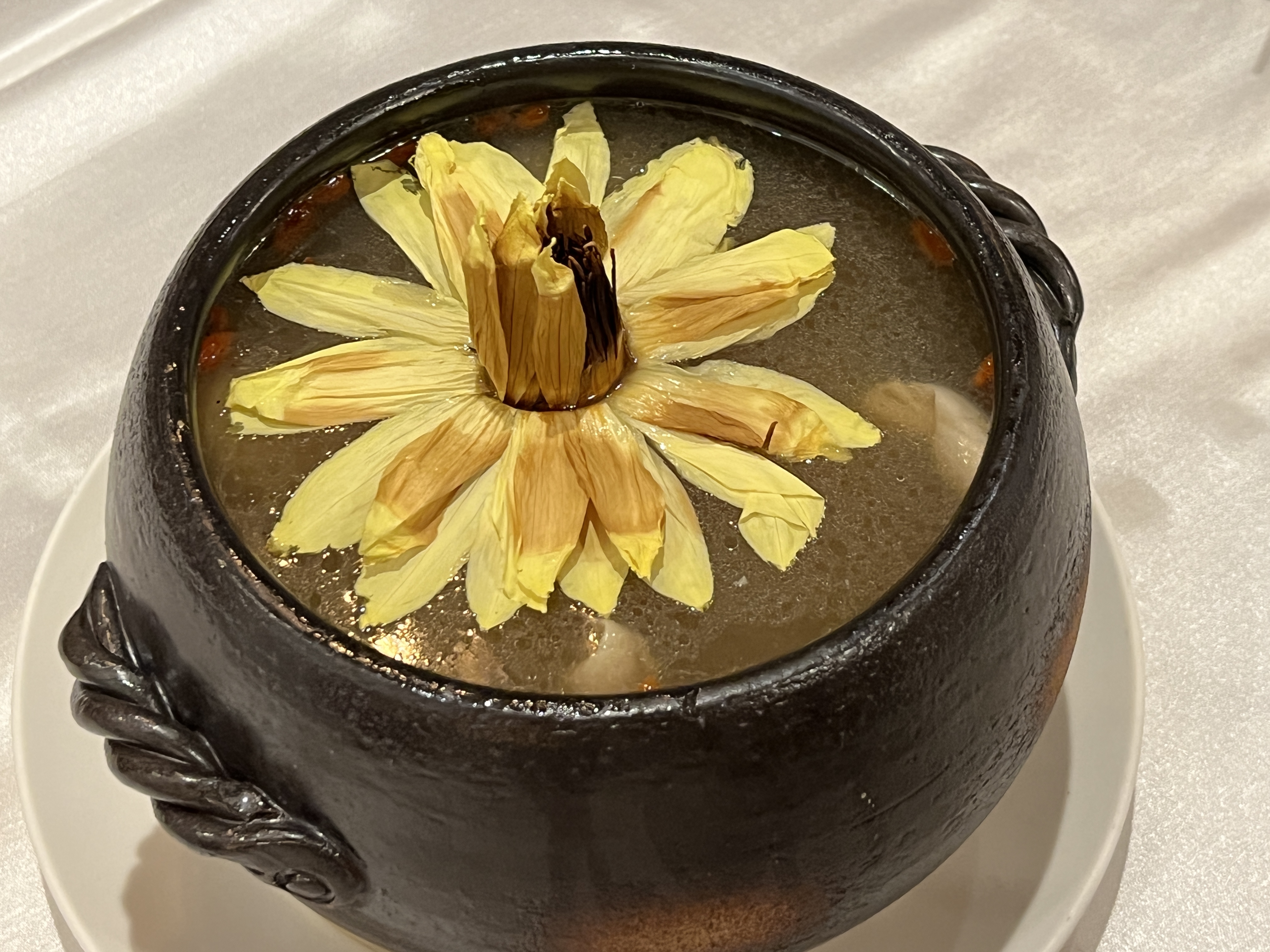 溫補的藥膳「蓮花養生鍋」裡放上一朵香水蓮花，身姿緩緩綻放。（1,800元／鍋）