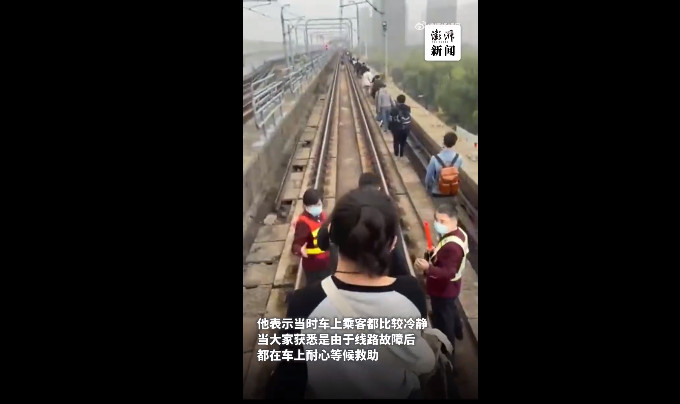 車上乘客在工作人員指導下疏散，依序離開車廂走在軌道上撤離。（翻攝微博@梨視頻）