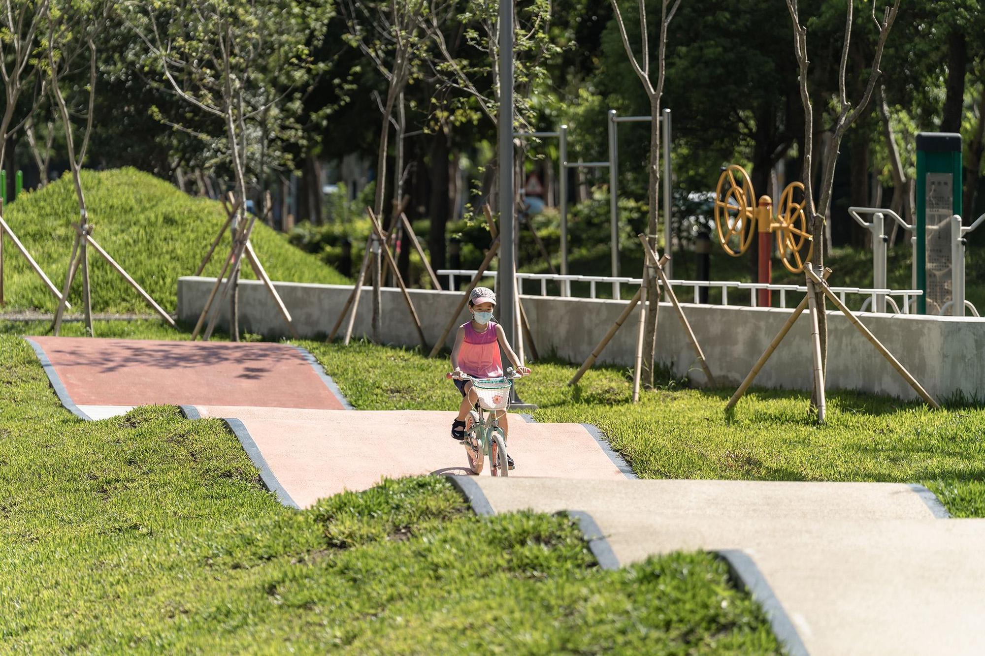 興隆公園串連起園內不同功能性的遊具，利用地形變化設計出具有高低起伏並環繞基地的輪具車道。（新竹縣提供）