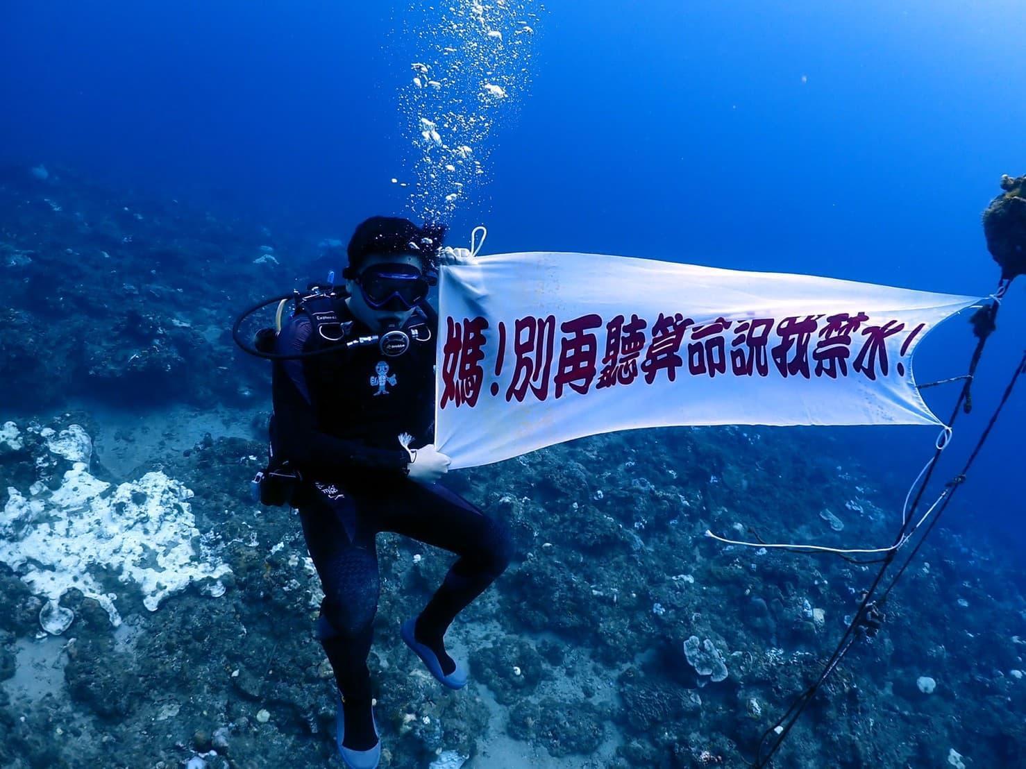 為了打破算命師的「命中忌水」說法,陳家田直接潛到海底拉布條向媽媽喊話。(陳家田授權提供)