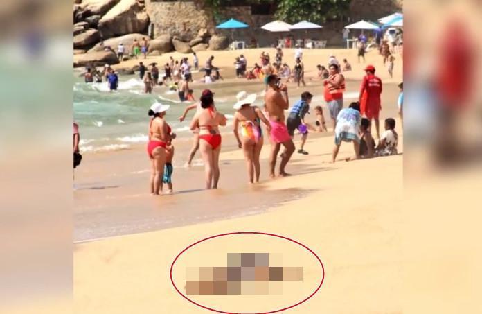 墨西哥阿卡普科一處沙灘有屍體被沖上岸邊,遊客們卻無視屍體就在身邊,繼續淡定玩水。(翻攝推特@gchahal)