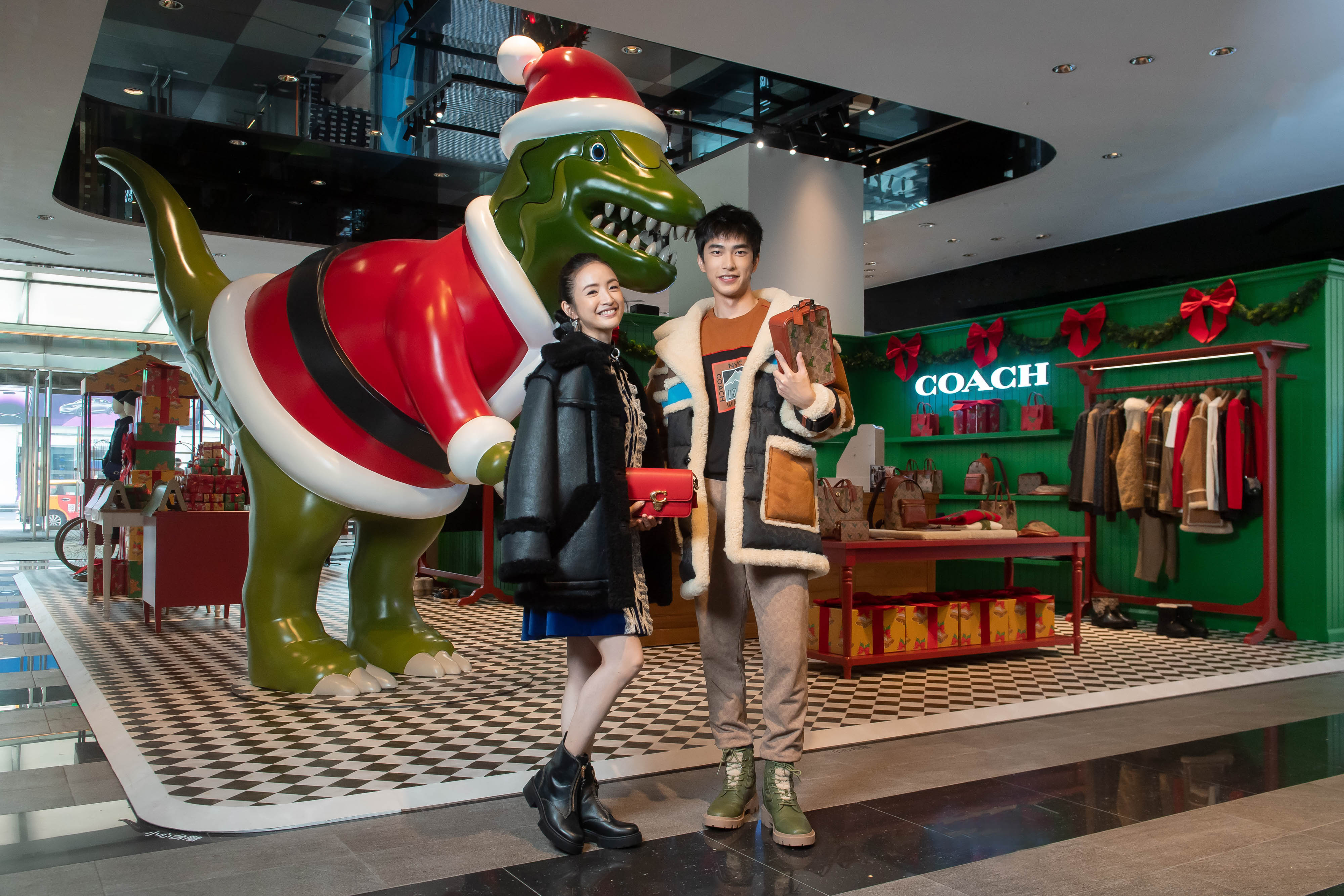.（左起）林依晨、曾敬驊以嘉賓身份出席COACH Holiday快閃店開幕活動，並與近3公尺高的節慶造型Rexy恐龍合影。（COACH提供）