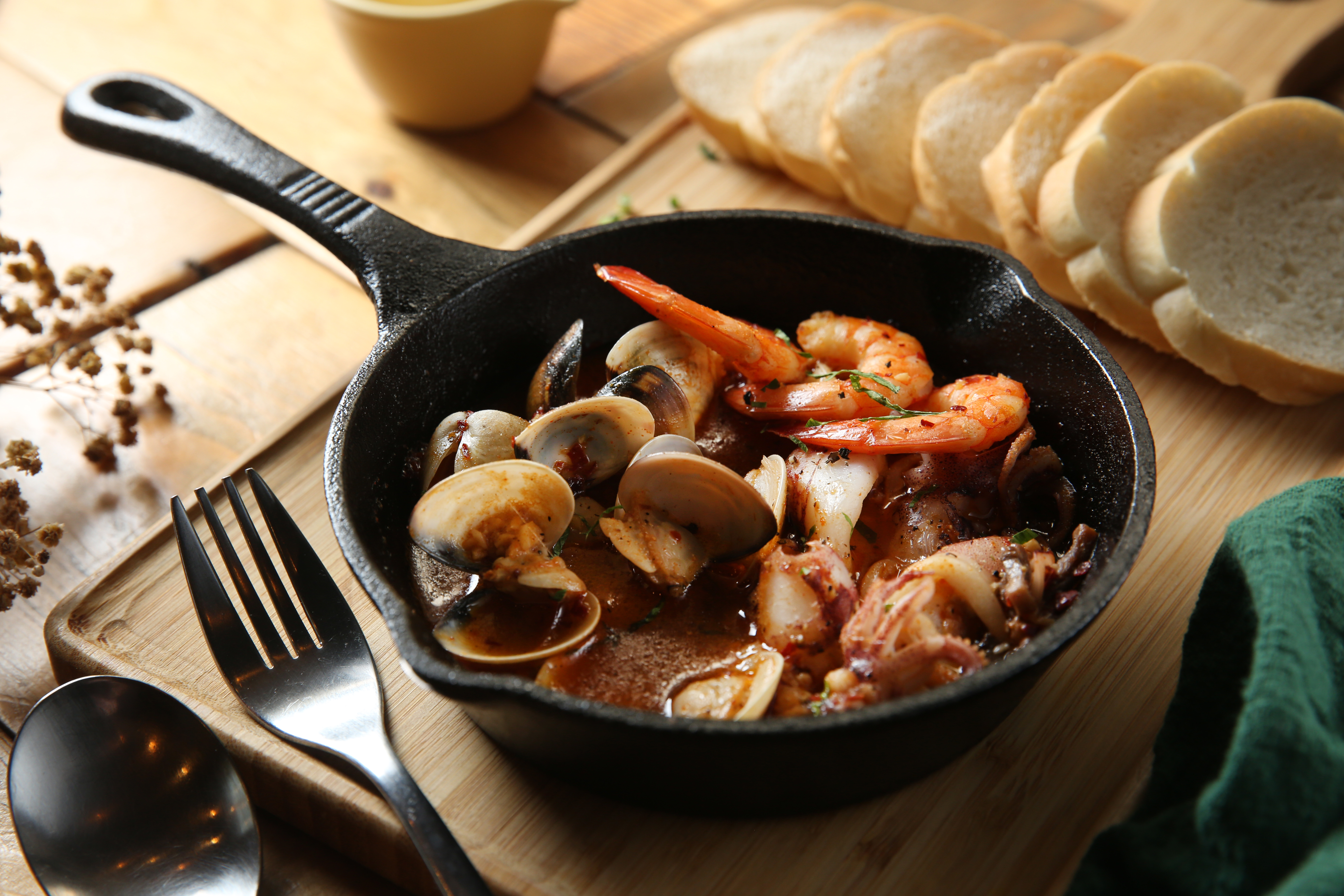 「西班牙蓋酒菜」用飽滿的蒜香橄欖油裹著海鮮，湯汁蘸薄皮法棍最對味。（250元／份）