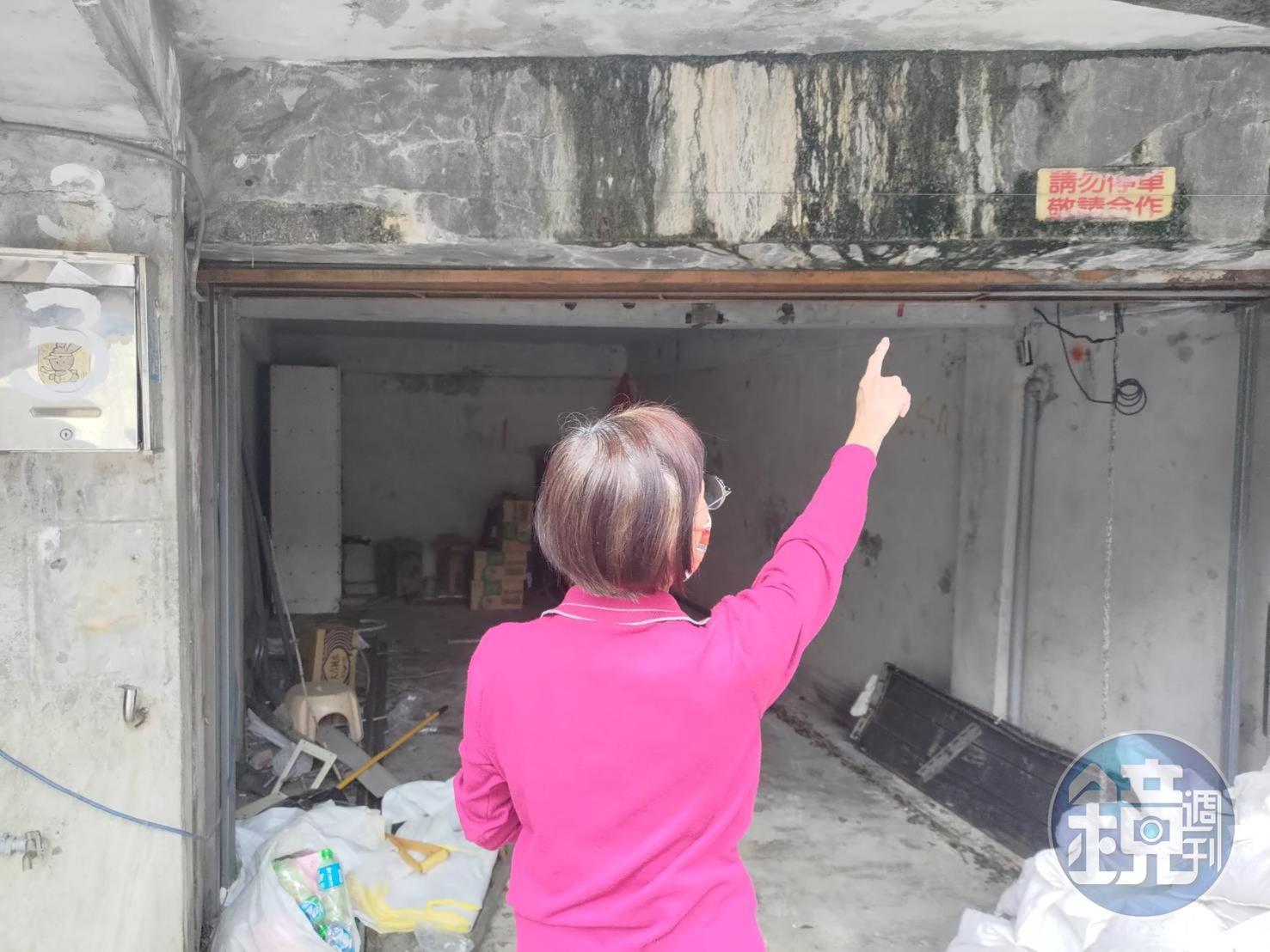 丁婦指著自家車庫,控訴鄰居楊姓醫師必須拆違建卻卸責。