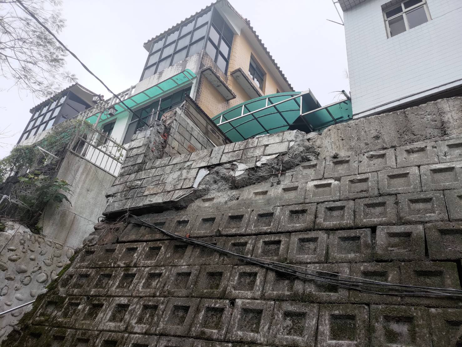 丁婦指控鄰居因興建違建駁坎等違建壓壞其車庫，卻仗著妻子是法官而卸責。