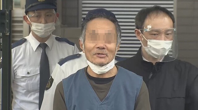 河嫌疑似砍妻百刀，被捕後對媒體露出詭異笑容。（翻攝自livedoor網站）