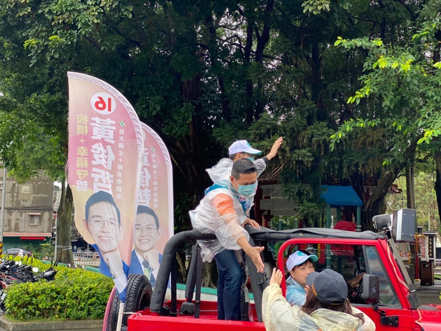 深受選舉「穩當選、男性保障名額」謠言所苦，立委羅致政陪同新北市議員黃俊哲冒雨掃街拉抬選情。（黃俊哲提供）