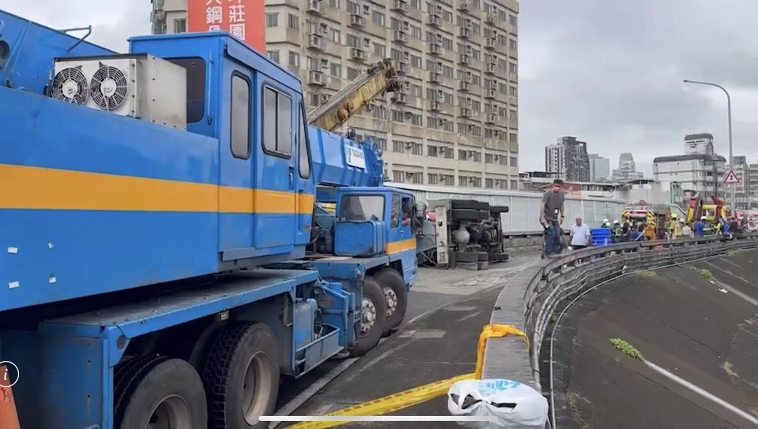 預拌車翻覆意外造成路面滿是水泥,吊車隨後到場將車輛吊離。(翻攝畫面)