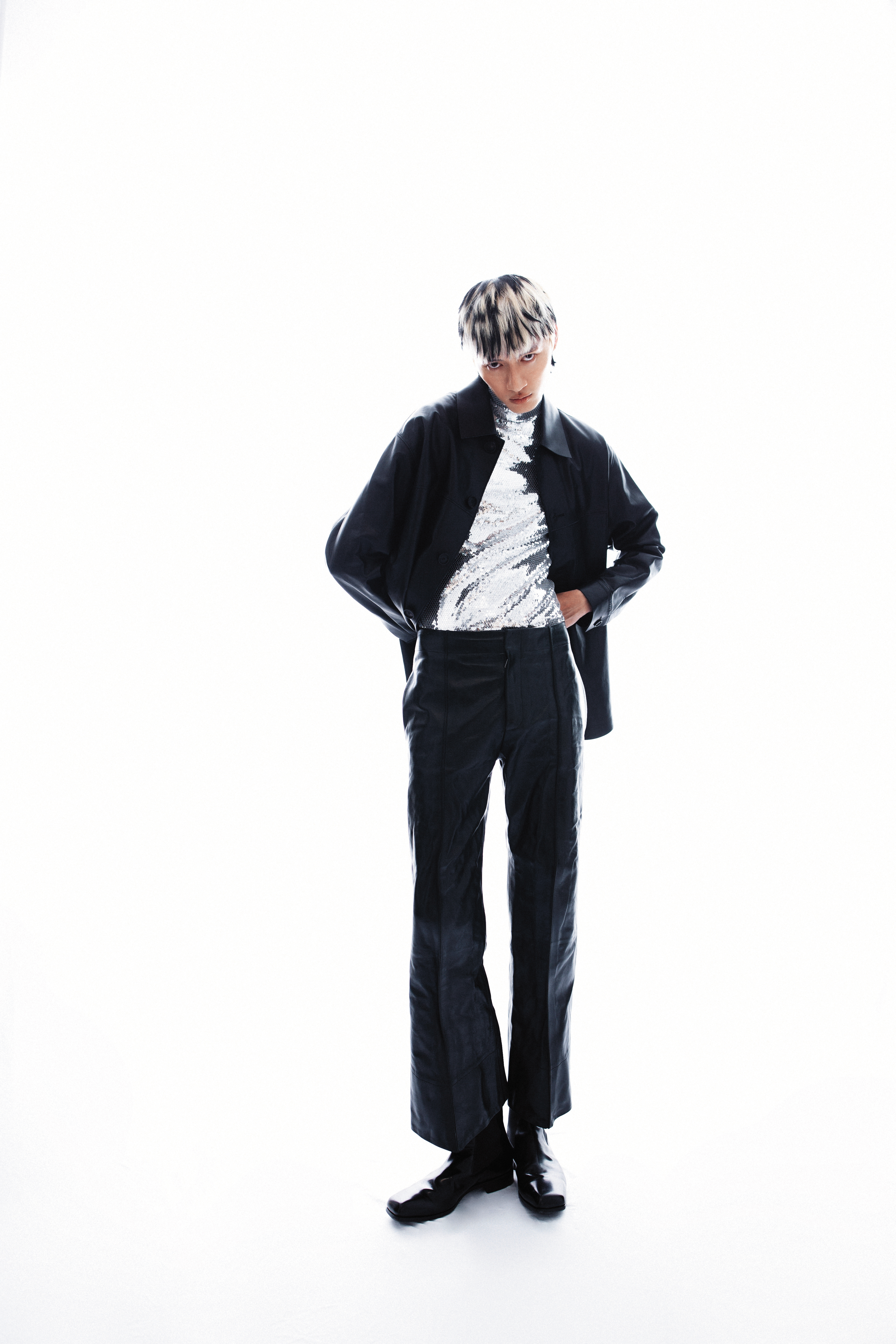David Lynch黑色皮革襯衫 NT$86,880 by peter wu；黑色皮革喇叭褲 價格店洽 by BOTTEGA VENETA；銀色內搭上衣 NT$72,000 by CELINE；黑色短靴 價格店洽 by PRADA。