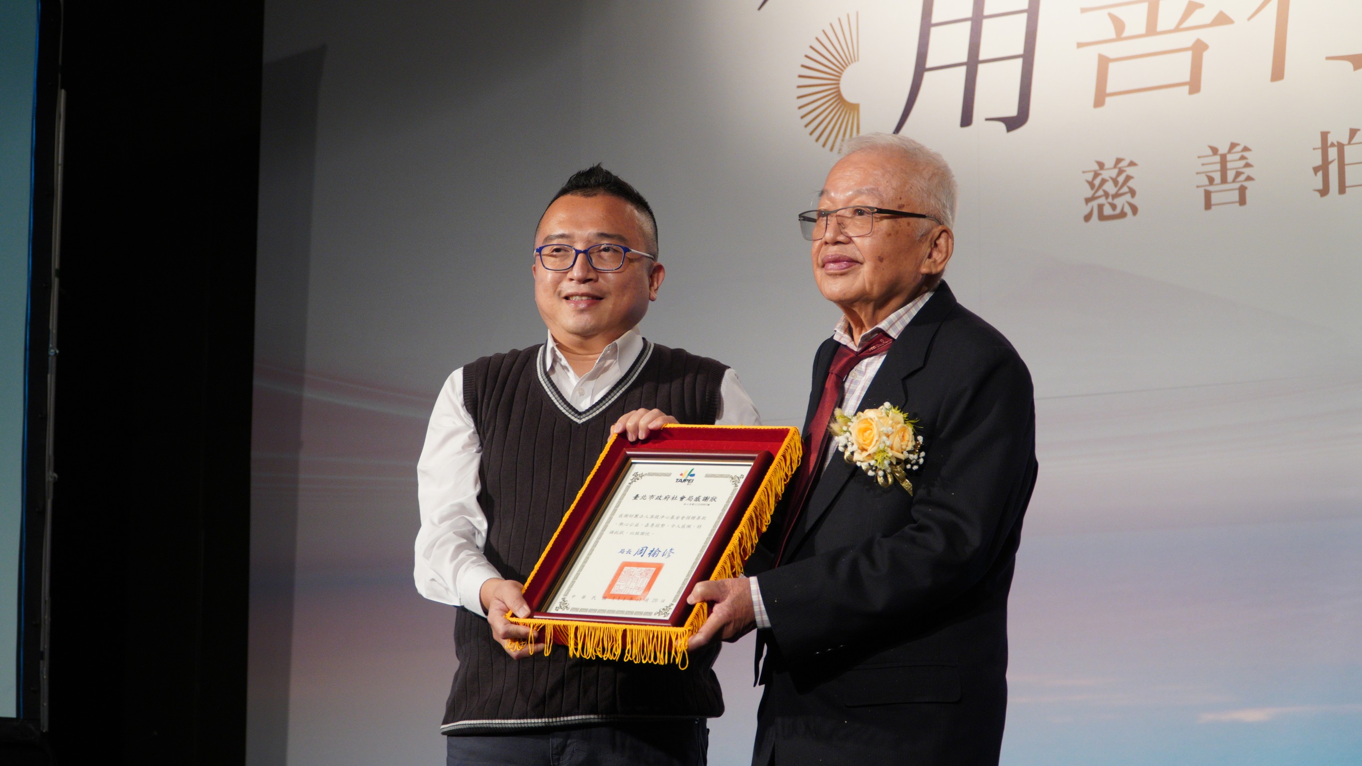 台北市政府社會局長周榆修頒贈感謝狀予基金會，由董事長劉泰英代表接受。（准提淨心基金會提供）