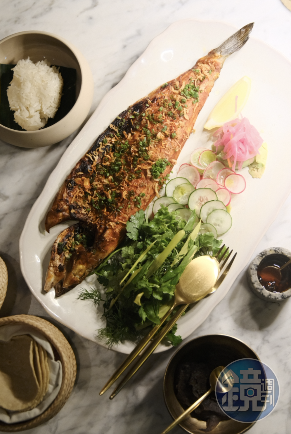 「PESCADO ZARANDEADO」整尾烤魚撒上油蔥、酪梨、阿斗波醬、辣椒等佐料，搭配餅皮一同上桌。（1,500泰銖／份，約NT$1,285）