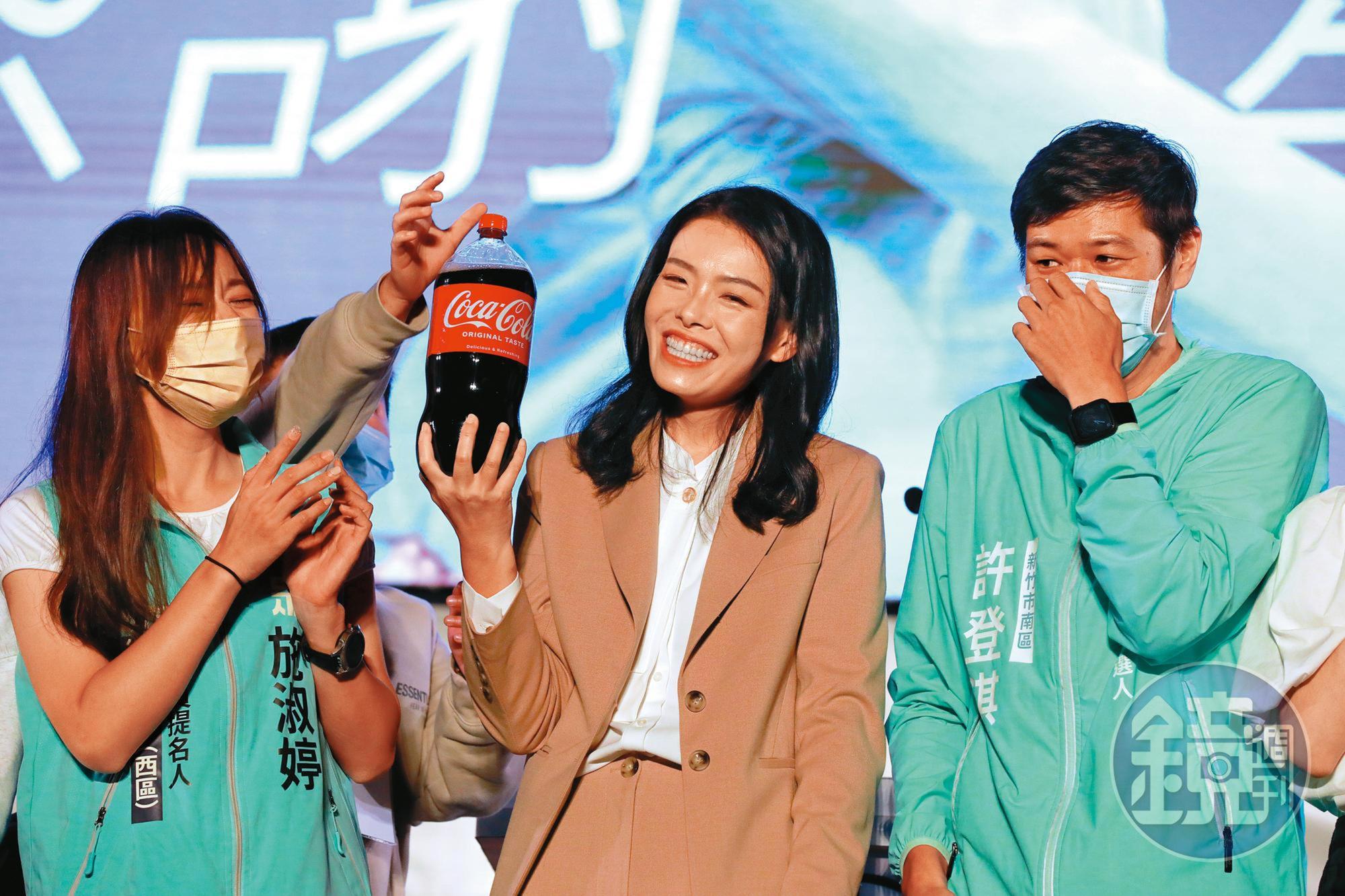 勝選之夜快結束時,有熱情民眾衝上台送了高虹安(中)可樂。