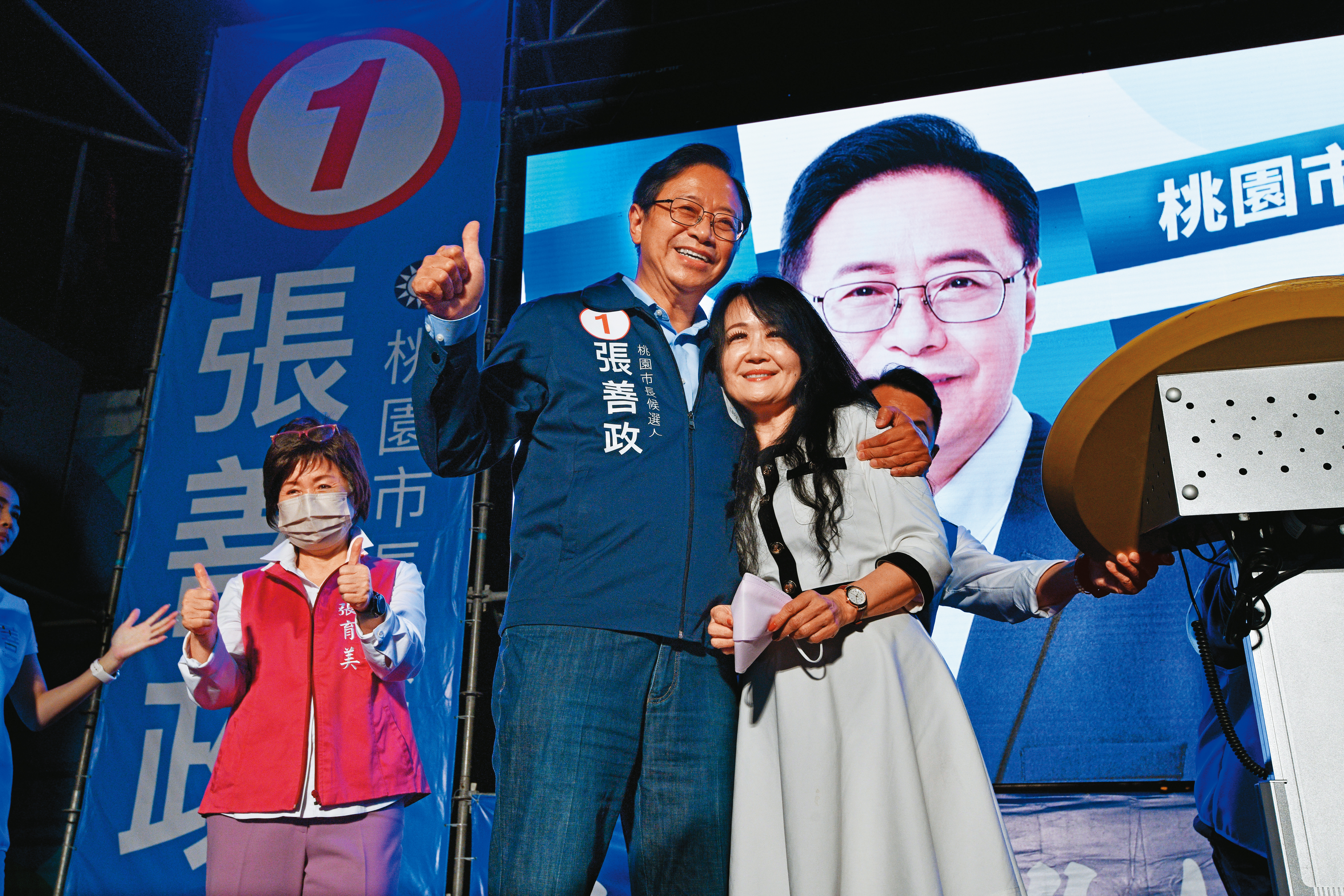 張善政（左）大勝對手超過10萬票，選得比預料中好，他上台謝票時特別拿下口罩，露出少見的大微笑。