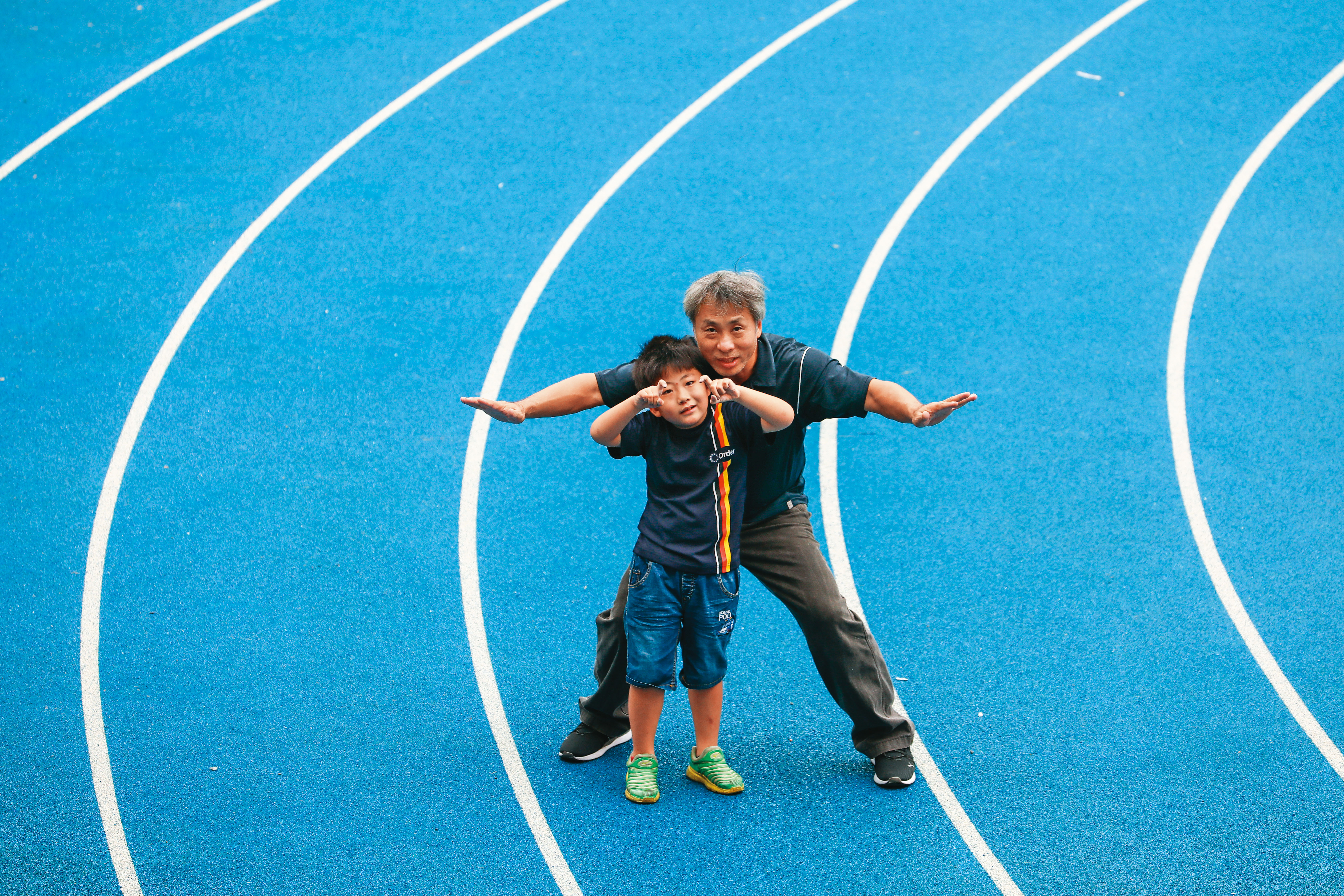 楊鈞文（後）每天都陪患有罕病小胖威利症的兒子（前）上課、游泳、跑步。