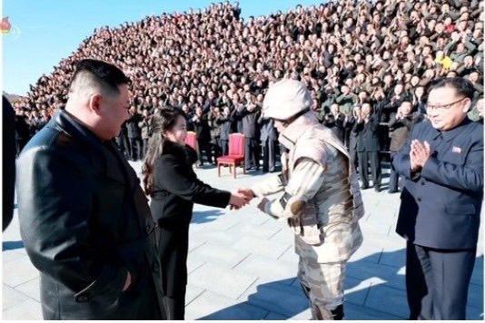 北韓官員(右)畢恭畢敬地和金主愛(中)握手。(翻攝自朝鮮中央TV)