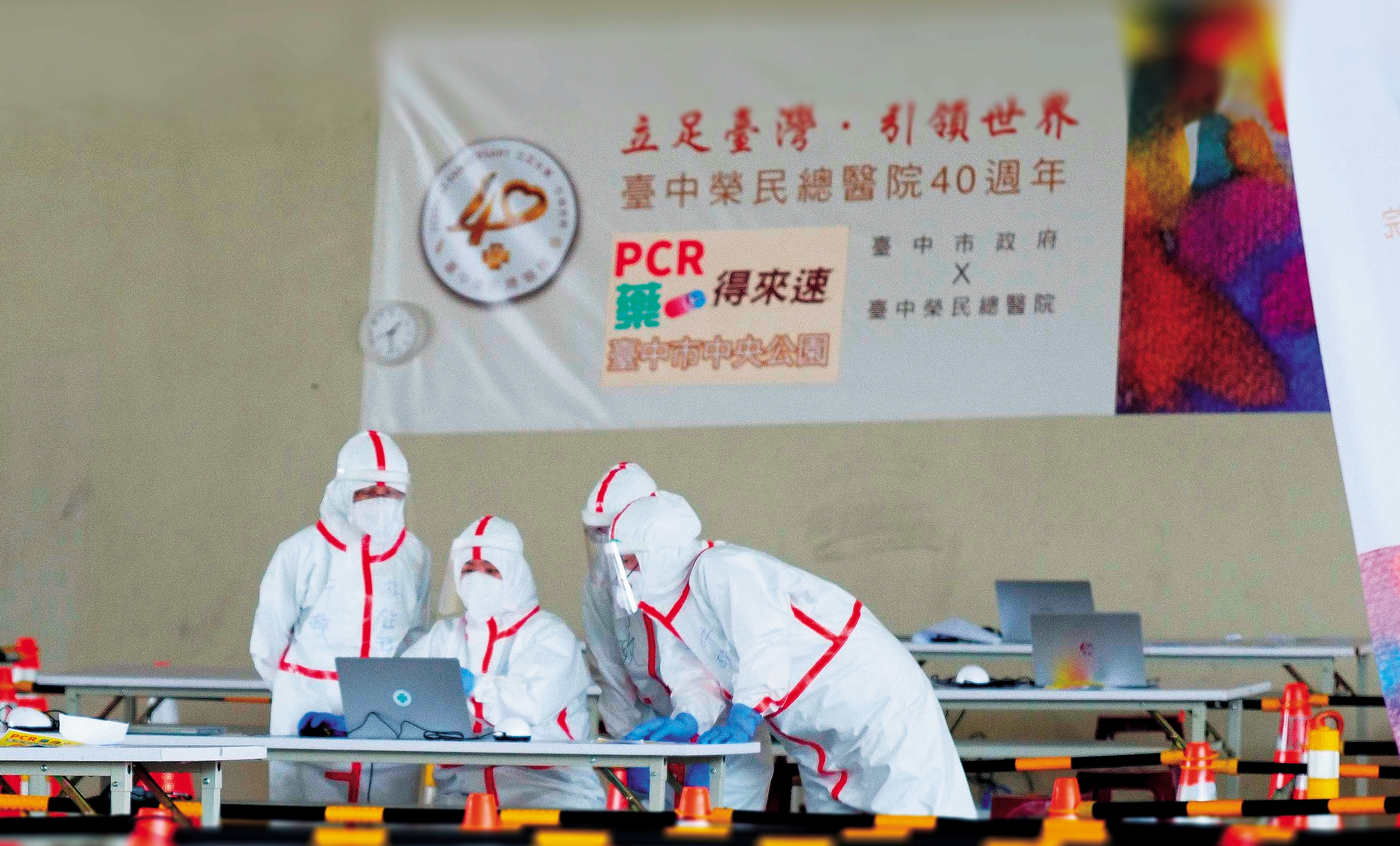 今年5月，因應疫情洪峰，設置「PCR給藥得來速」大型篩檢站。服務醫護人員身著完整裝備進行前置作業。