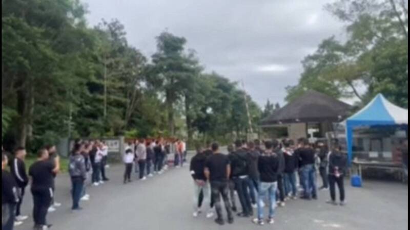 百名黑衣人高調接風王志成，高調行徑引人側目。（翻攝畫面）